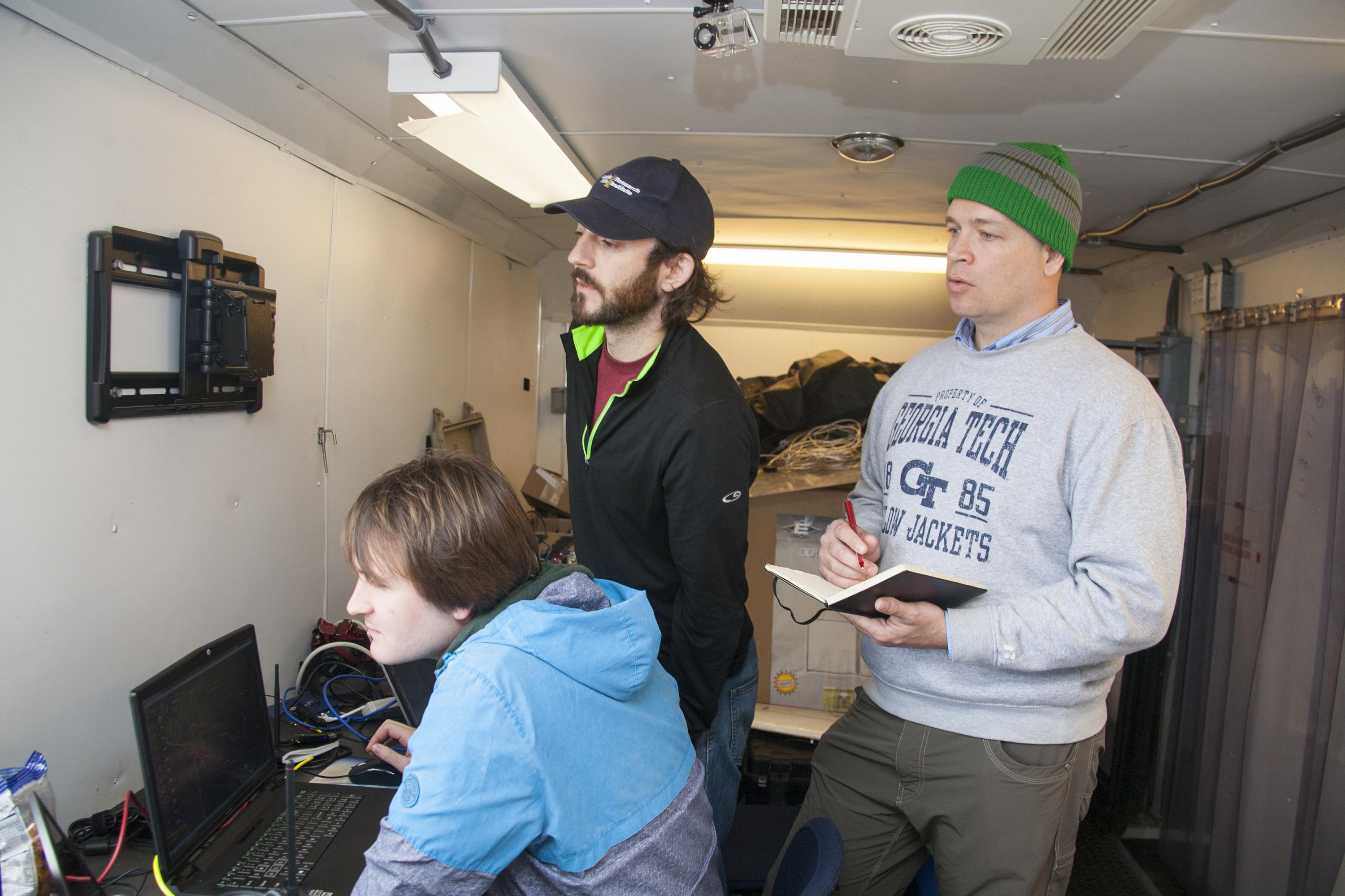 Georgia Tech Research Institute team members (l-r) David Jensen, Kevin DeMarco and Charles Pippin are shown preparing for a demonstration between two swarms of unmanned air vehicles. (U.S. Navy photo by Javier Chagoya)
