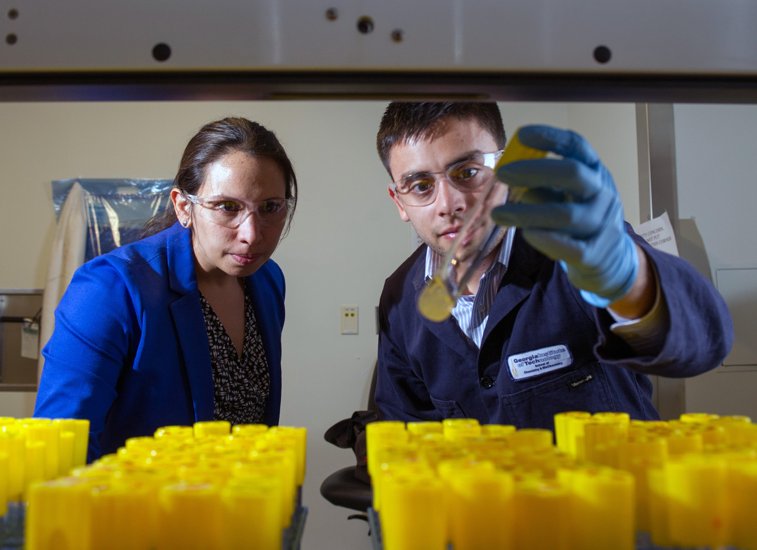 Georgia Tech researchers examine the production of the hydrocarbon pinene in a series of laboratory test tubes. Shown are (l-r) Pamela Peralta-Yahya, an assistant professor in the School of Chemistry and Biochemistry and the School of Chemical and Biomolecular Engineering, and Stephen Sarria, a graduate student in the School of Chemistry and Biochemistry. (Georgia Tech Photo: Rob Felt)
