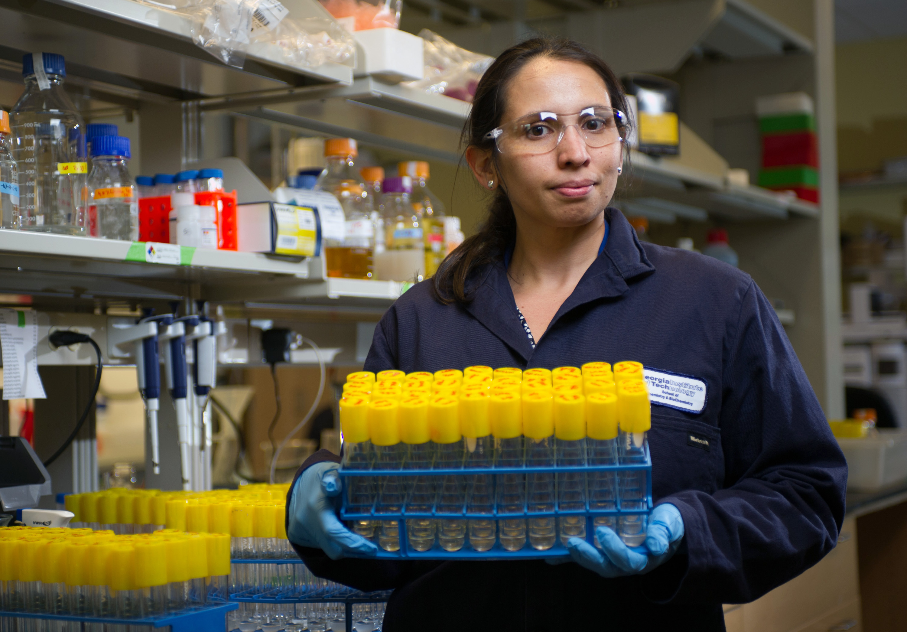 Pamela Peralta-Yahya, an assistant professor in the Georgia Tech School of Chemistry and Biochemistry and the School of Chemical and Biomolecular Engineering, shows samples used to study the production of pinene by colonies of bioengineered E. coli. (Georgia Tech Photo: Rob Felt)
