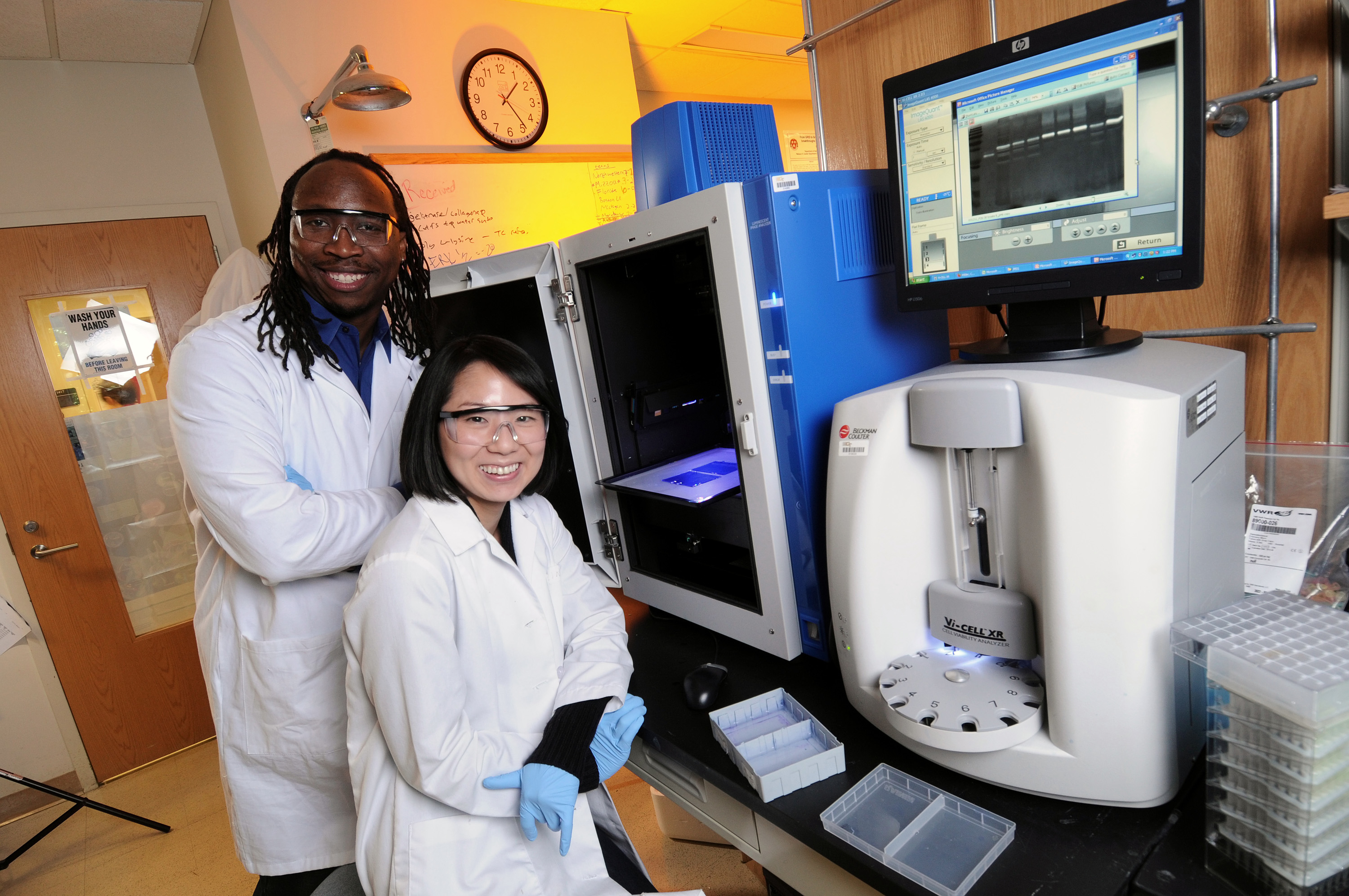 Manu Platt (left), an associate professor in the Wallace H. Coulter Department of Biomedical Engineering at Georgia Tech and Emory University, and graduate student Keon-Young Park, produce high-quality images from the gels shown to quantify cathepsin activity. In a new study, the researchers are studying levels of cathepsins and other signaling chemicals in an effort to predict the invasiveness of breast cancer in individual patients. (Credit: Gary Meek, Georgia Tech)