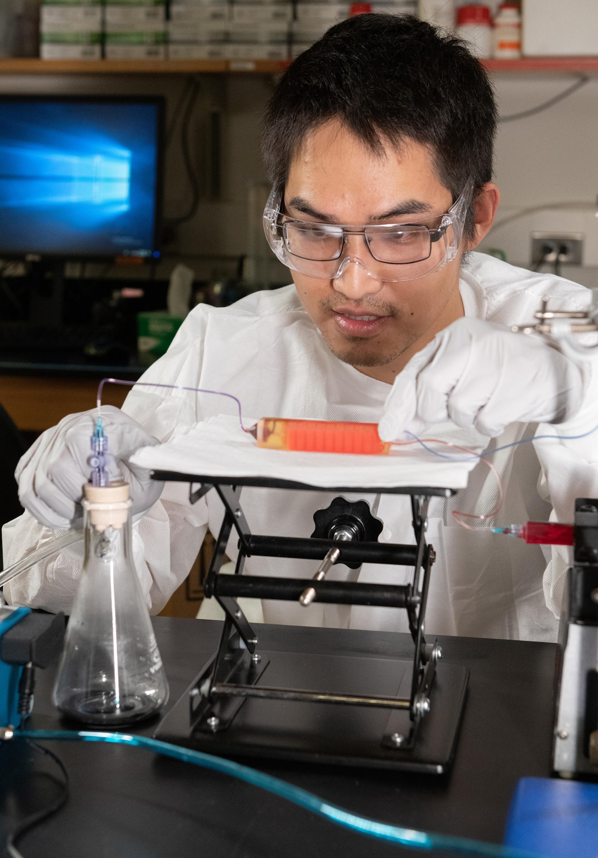 Graduate Student Chia-Heng Chu adjusts a 3D-printed cell trap in the laboratory of Assistant Professor A. Fatih Sarioglu at Georgia Tech. The trap captures white blood cells to isolate tumor cells from a blood sample. (Photo: Allison Carter, Georgia Tech)