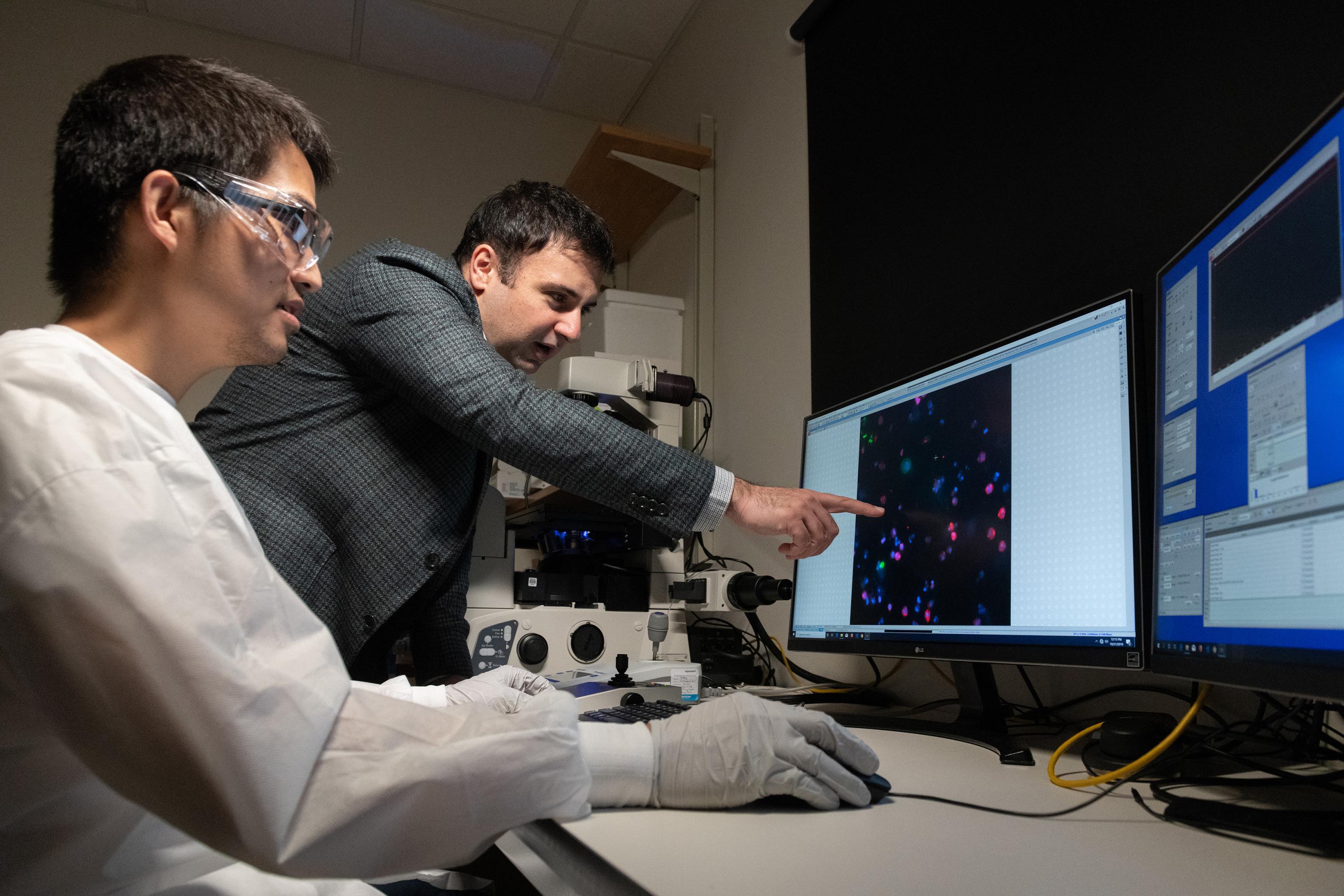 Georgia Tech Graduate Student Chia-Heng Chu and Assistant Professor A. Fatih Sarioglu examine tumor cells captured using their 3D-printed cell trap. The trap captures white blood cells to isolate tumor cells from a blood sample. (Photo: Allison Carter, Georgia Tech)