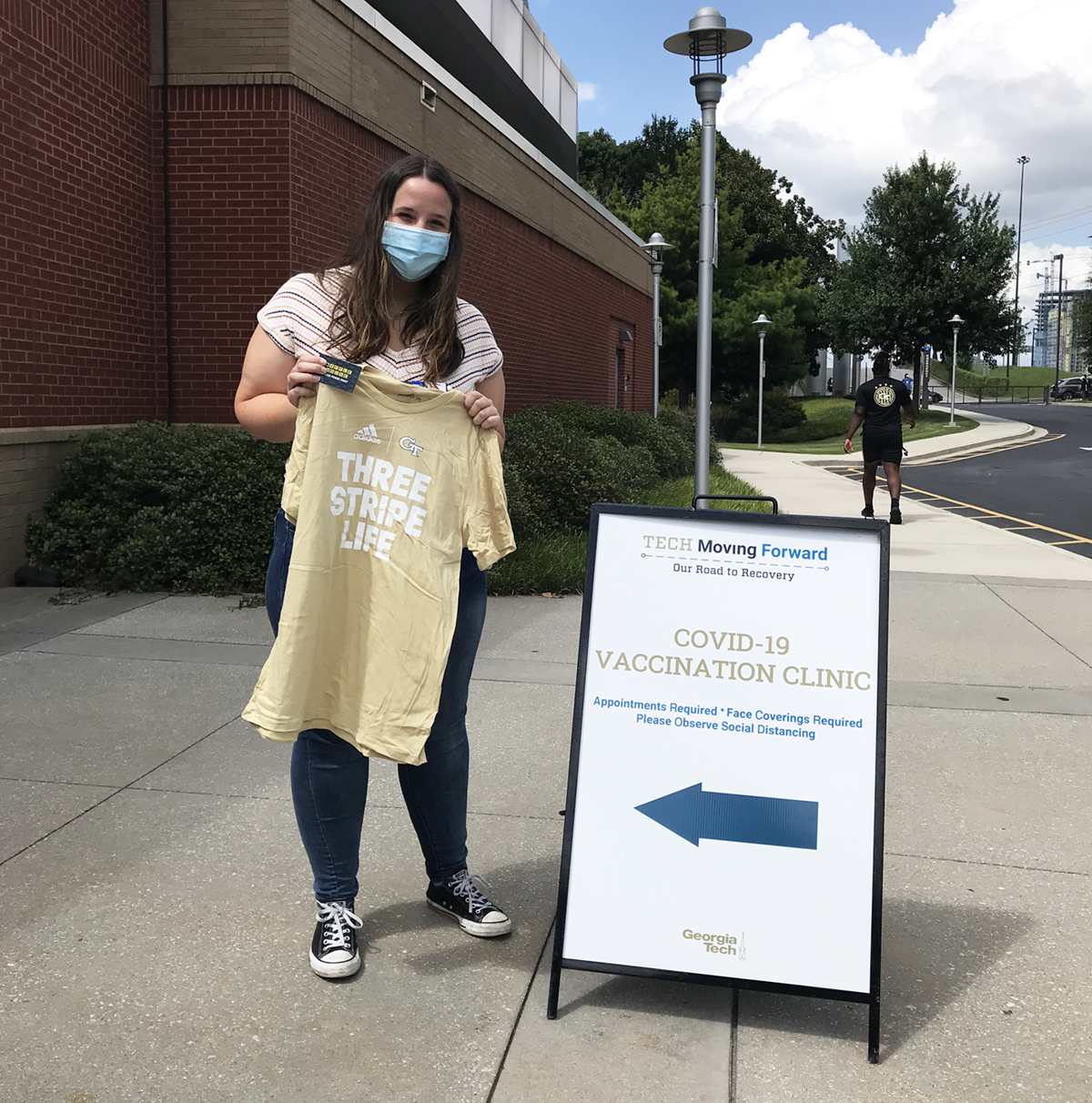 Vaccine clinic volunteer Claire, a third-year student studying biochemistry, holds one of the GT Athletics t-shirts handed out at a recent campus clinic. This month, all students, faculty, and staff who get vaccinated or participate in Covid-19 testing will be eligible for drawings and surprise giveaways of GT Athletics t-shirts and memorabilia, Barnes & Noble at Georgia Tech gift cards, and discount cards for Waffle House, Rusty Taco, and other local businesses.