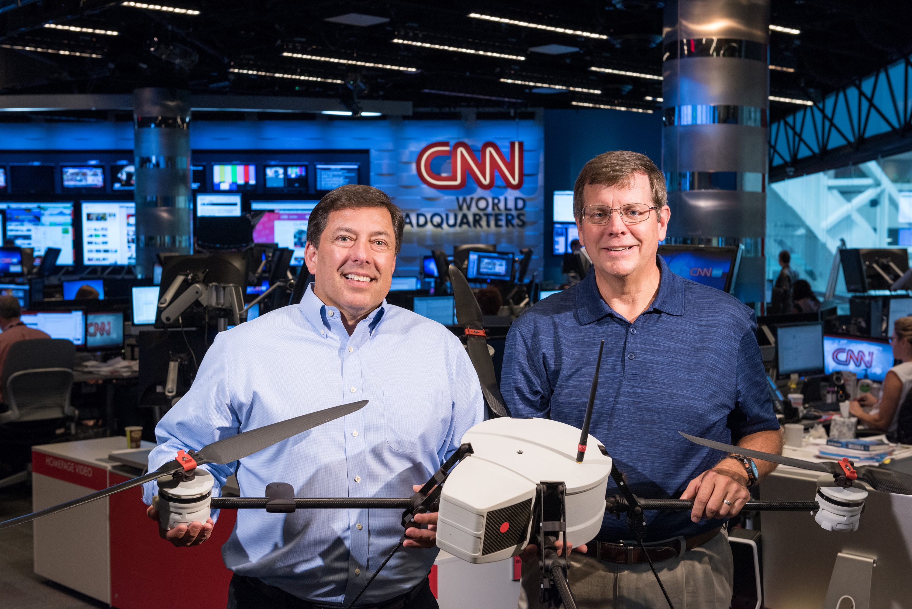 The Georgia Tech Research Institute (GTRI) and CNN have been working together to study the issues affecting the use of unmanned aerial vehicles for newsgathering. Shown in CNN’s World Headquarters are (left) Greg Agvent, senior director of news operations for CNN, and Cliff Eckert, a GTRI senior research associate who’s working on the project. They are shown with an AirRobot AR 180, one of the devices that may be suitable for newsgathering. (Credit: Rob Felt, Georgia Tech)