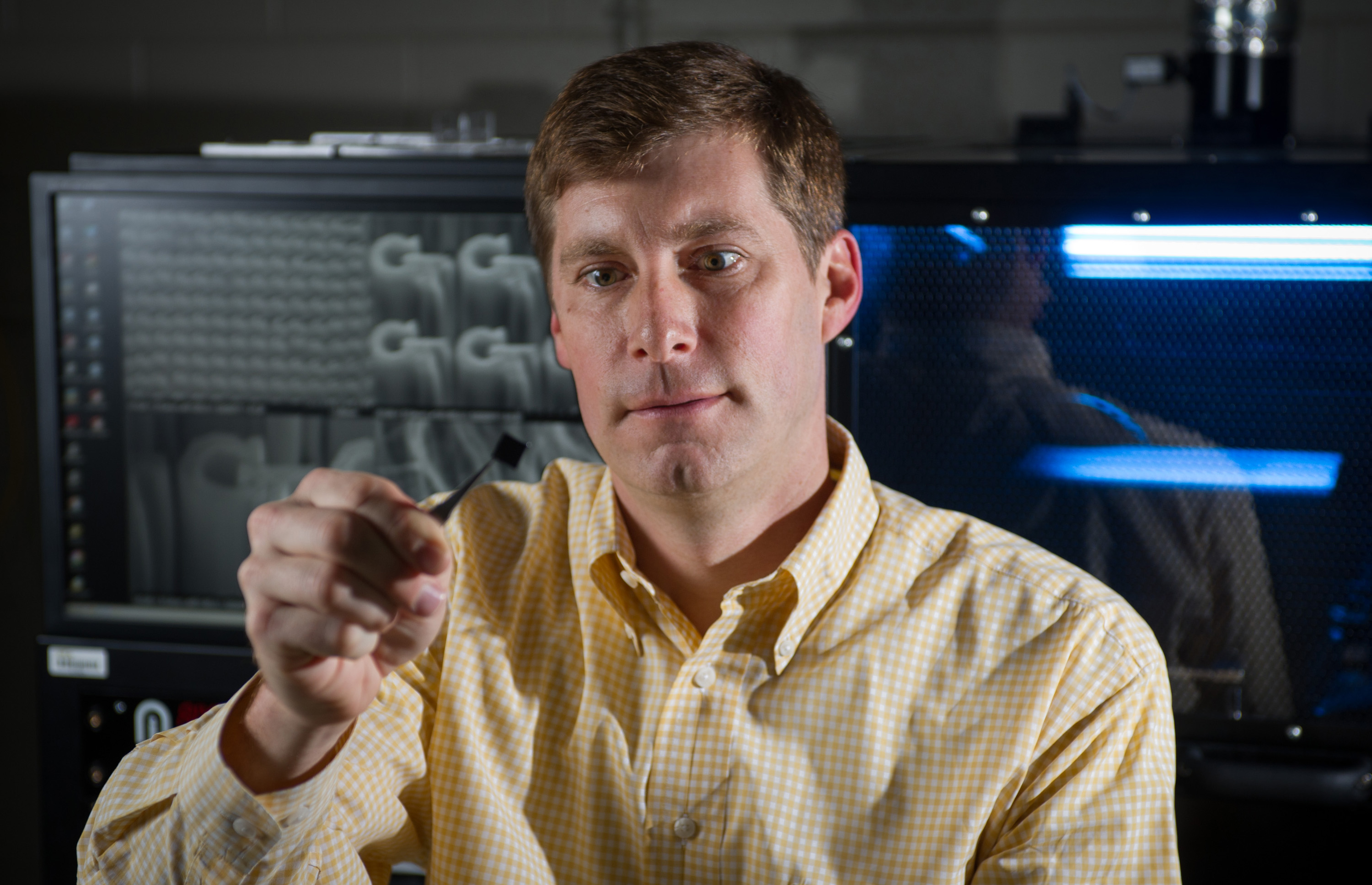 Jud Ready, a principal research engineer at the Georgia Tech Research Institute, holds a chip containing bundles of carbon nanotubes grown in pits. The nanotubes are being tested for potential use in future electrically-powered ion propulsion systems. (Georgia Tech Photo: Rob Felt)