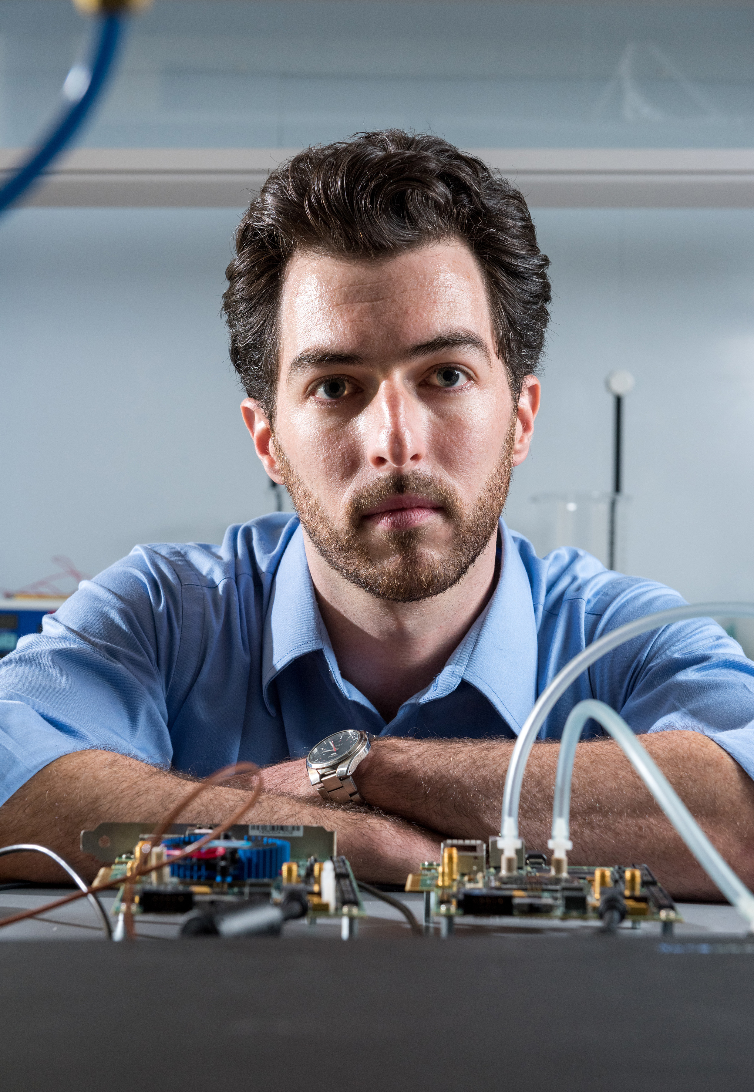 Georgia Tech graduate student Tom Sarvey is shown with test equipment used to compare the performance of stock FPGA devices, one with experimental liquid cooling and the other using stock air cooling. (Credit: Rob Felt, Georgia Tech)