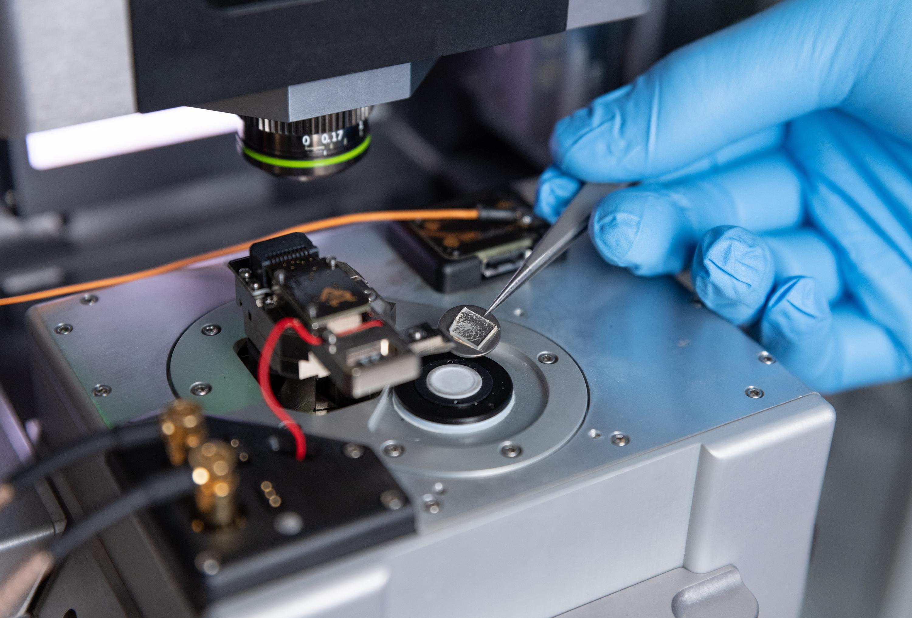 A single crystal sample is placed onto the measurement stage of the modified atomic force microscope (i.e. piezoresponse force microscope). (Photo: Rob Felt, Georgia Tech)