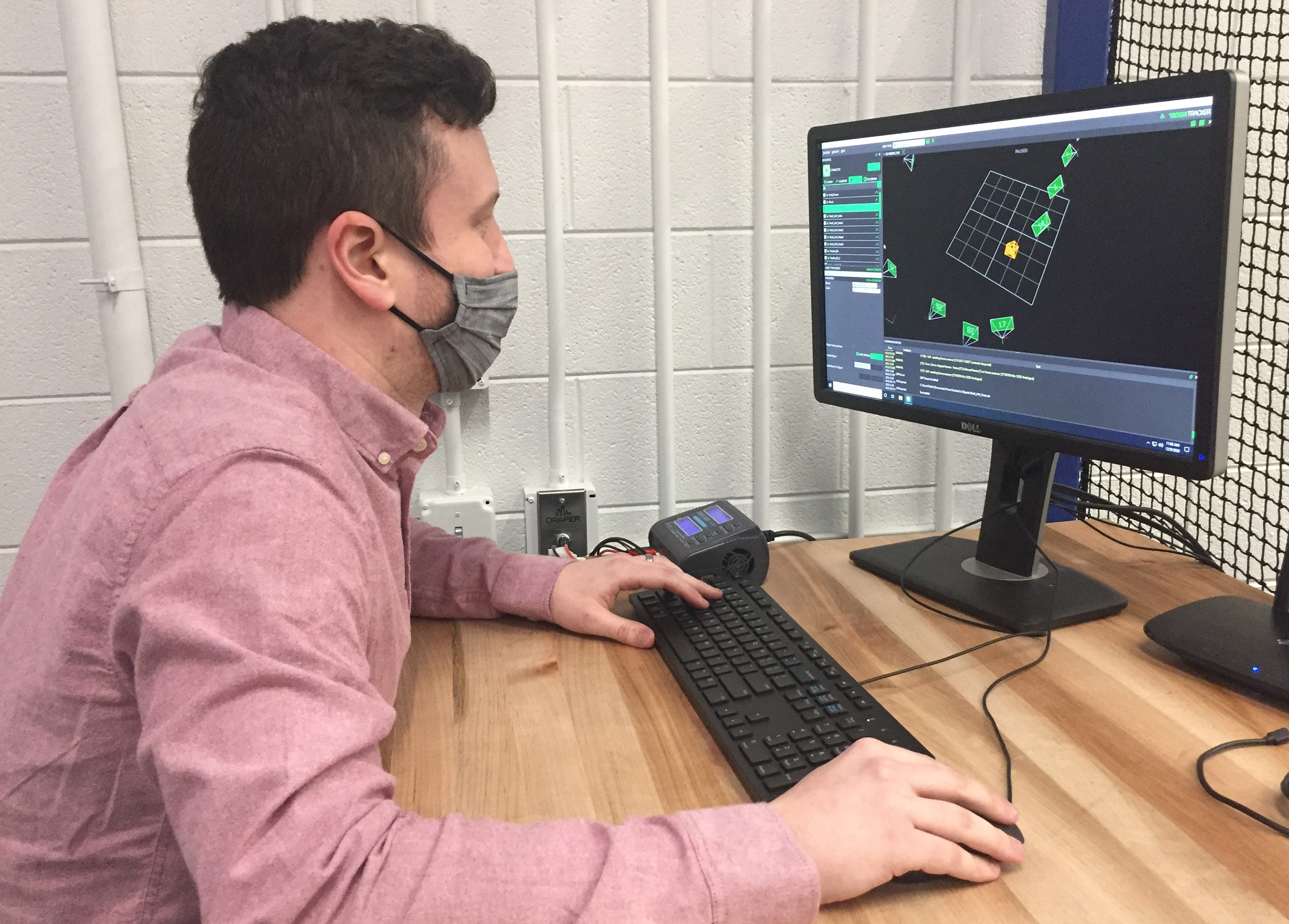 Graduate student Kevin Webb monitors the control algorithm that allows four drones to team up to pick up and deliver a package. (Credit: John Toon, Georgia Tech)