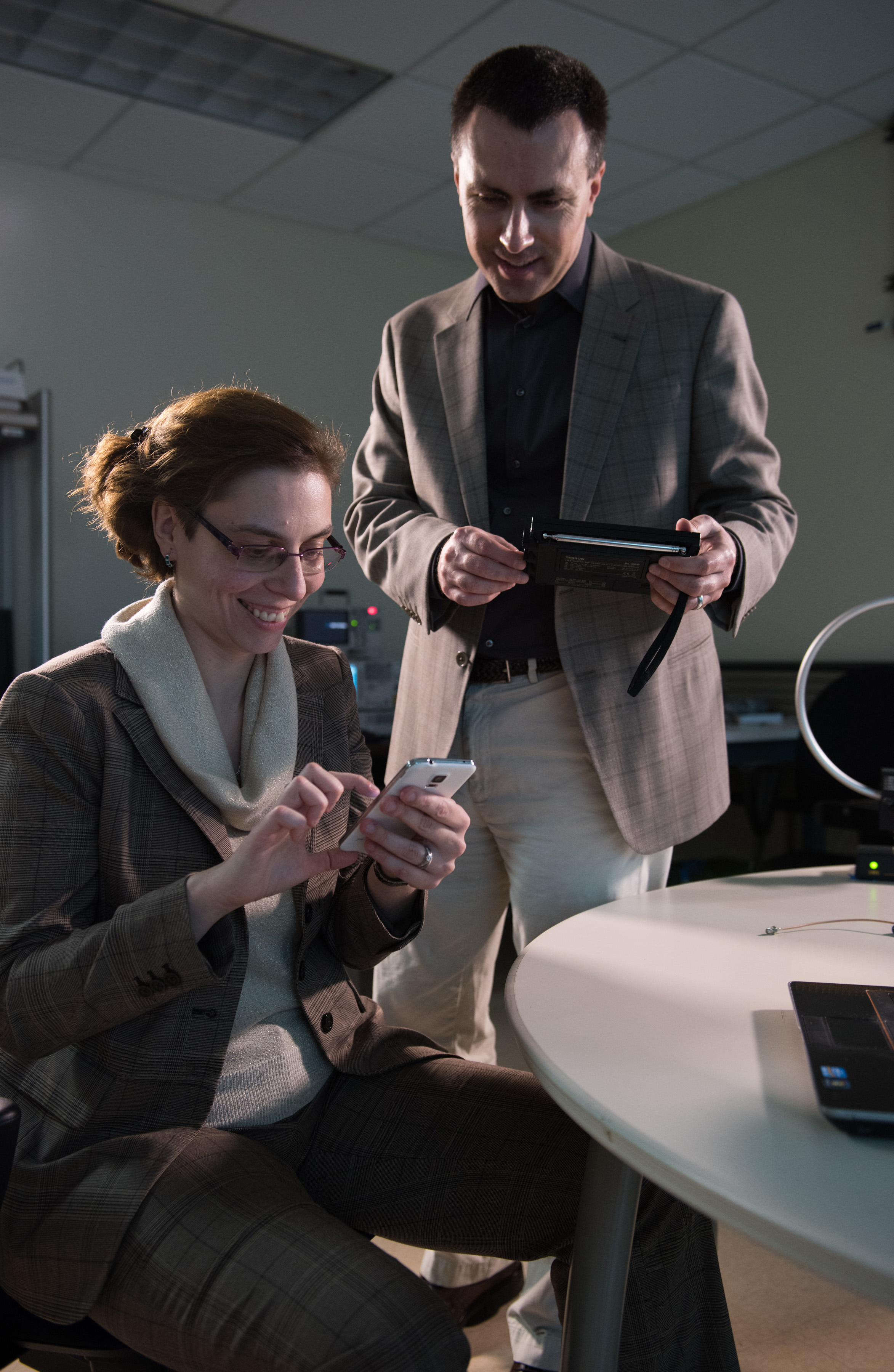 Georgia Tech researchers Alenka Zajic and Milos Prvulovic use a simple AM/FM radio to pick up side-channel signals from a cell phone. Such unintentional signals could be used to learn what computations are being done by the device.  (Credit: Rob Felt)