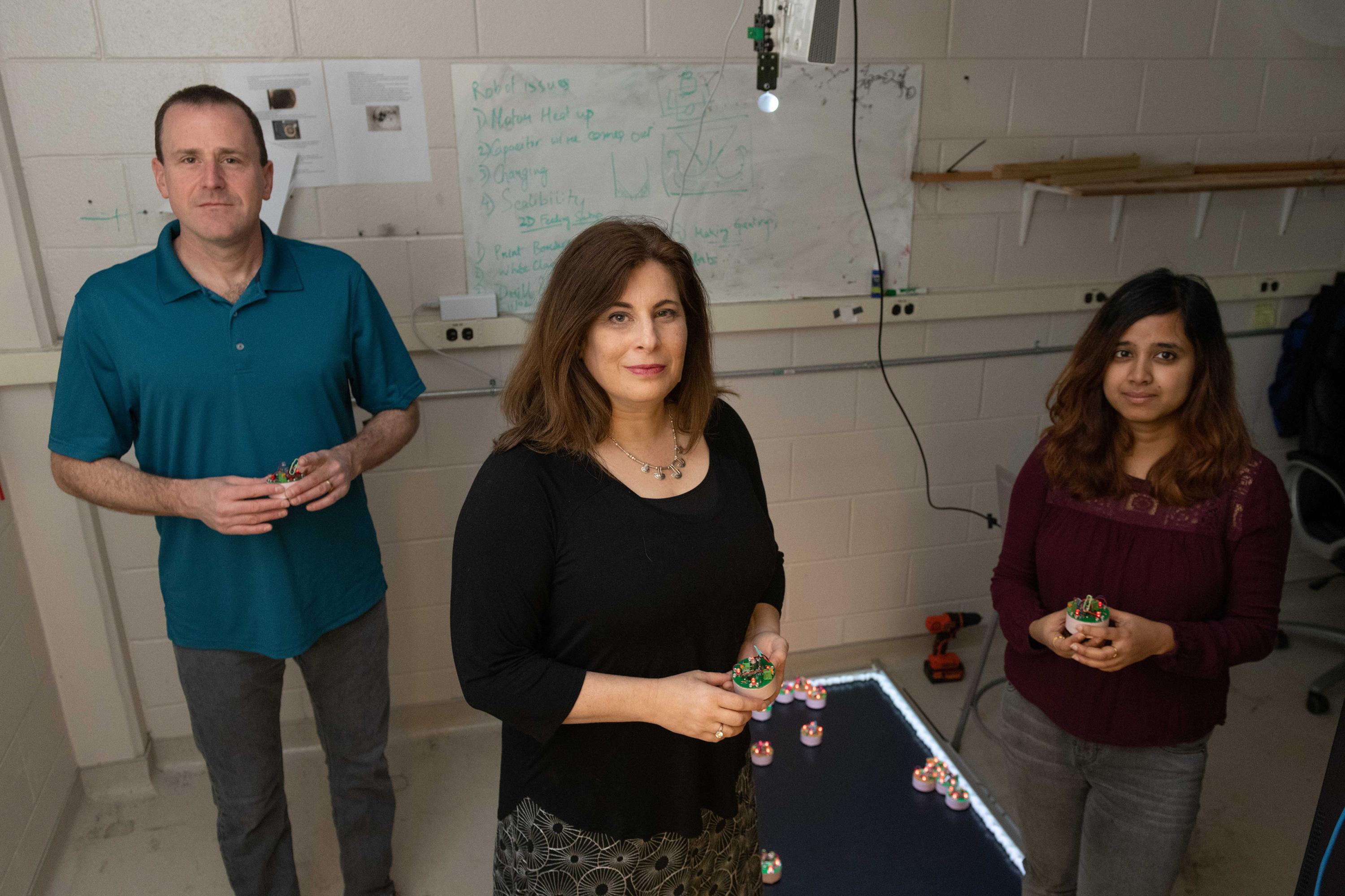 Researchers at the Georgia Institute of Technology have been awarded $6.25 million to use collective emergent behavior to achieve task-oriented objectives. Shown are Dan Goldman, professor in the School of Physics; Dana Randall, co-director of the Institute for Data Engineering and Science, and Ph.D. student Bahnisikha Dutta. (Photo: Allison Carter, Georgia Tech)