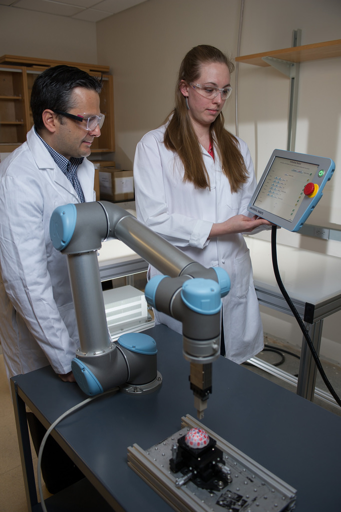 Facundo Fernandez (left) and Rachel Bennett, use a robotic arm to probe objects with irregularly-shaped surfaces for mass spectrometry.
