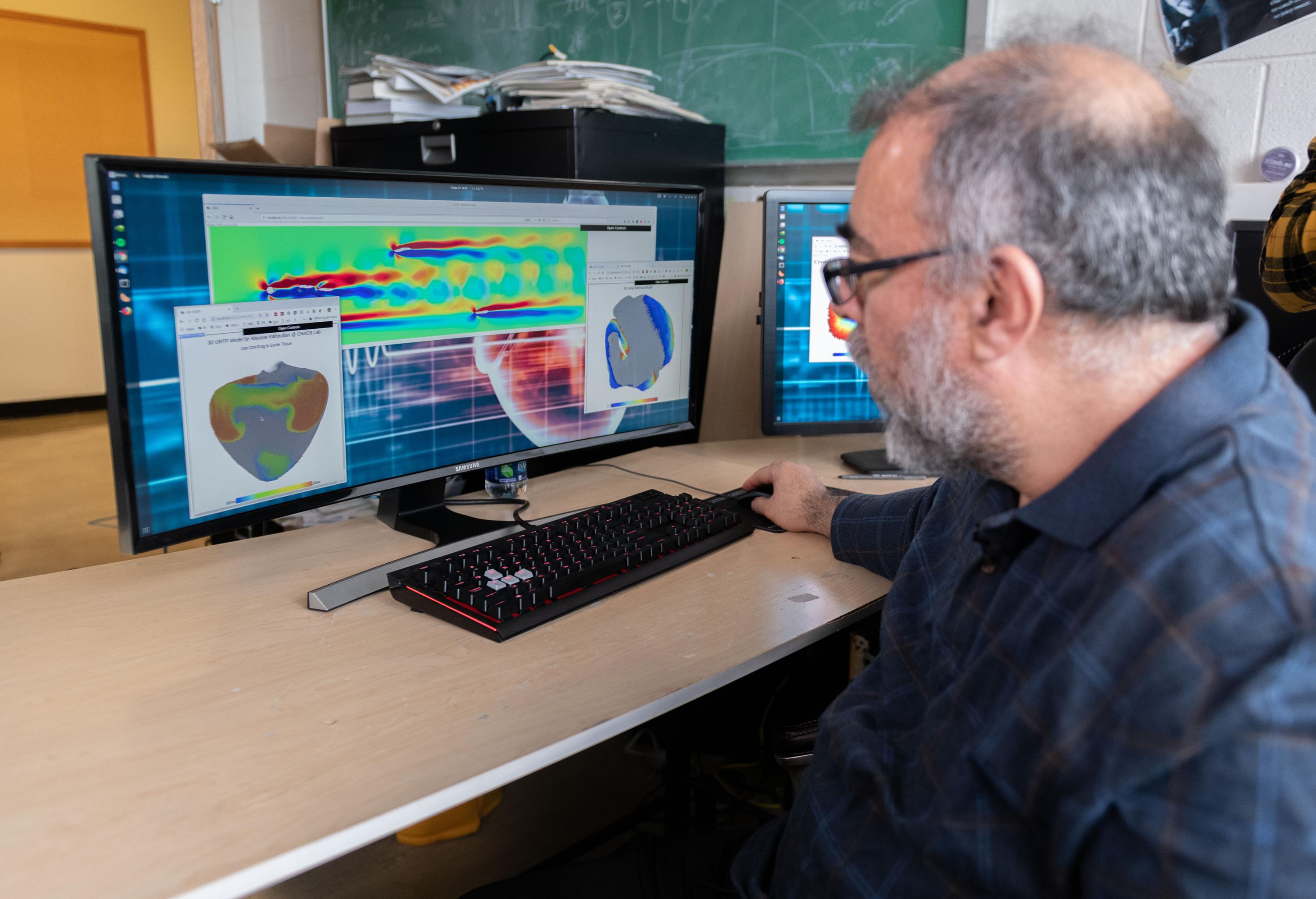 Flavio Fenton, a professor in the School of Physics at the Georgia Institute of Technology, examines cardiac and fluid flow simulations created on a system that uses graphics processing chips designed for gaming applications and software that runs on ordinary web browsers. (Photo: Allison Carter, Georgia Tech)