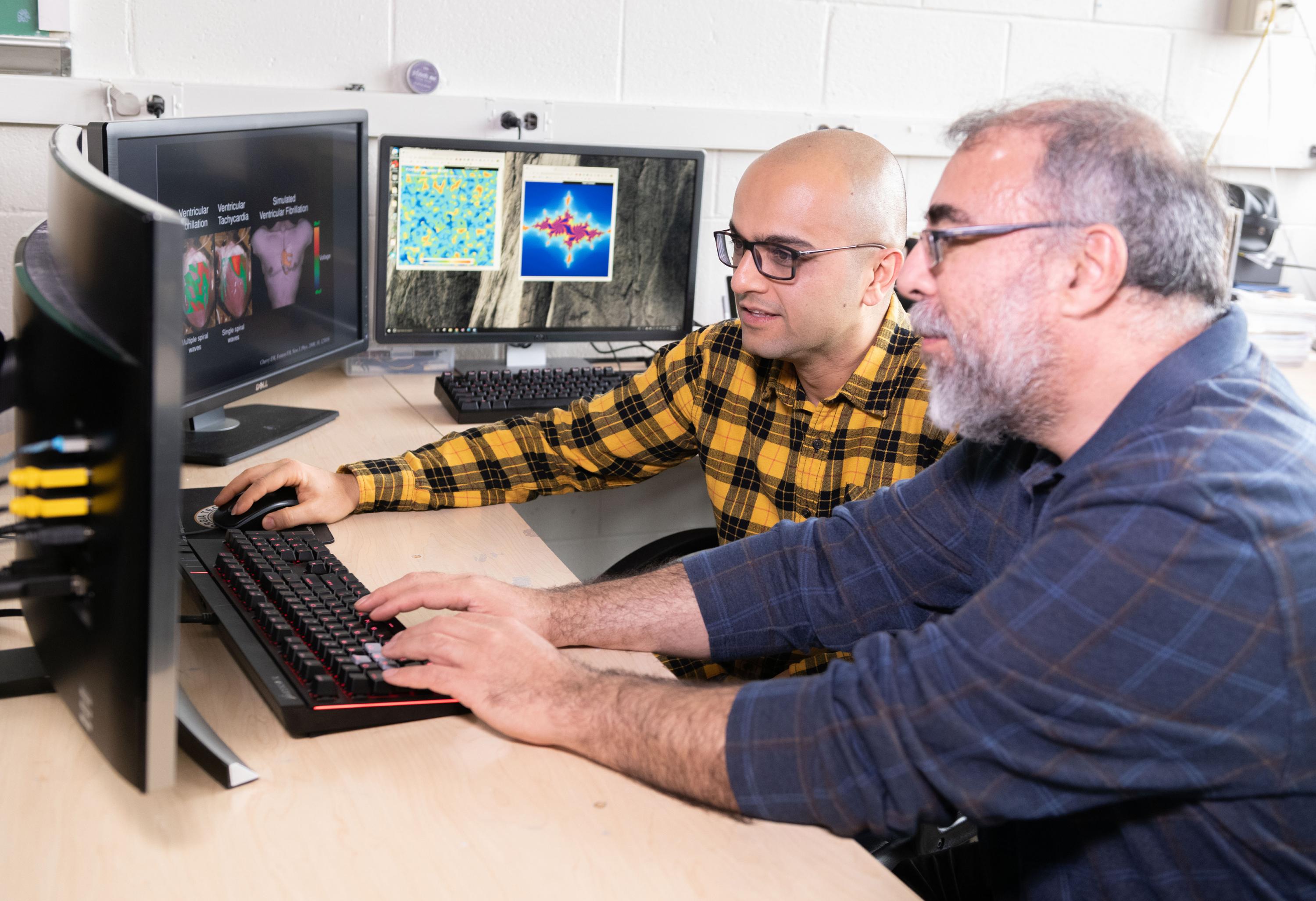 Professor Flavio Fenton and Research Scientist Abouzar Kaboudian discuss simulations running on a system that uses graphics processing chips designed for gaming applications and software that runs on ordinary web browsers. (Photo: Allison Carter, Georgia Tech)