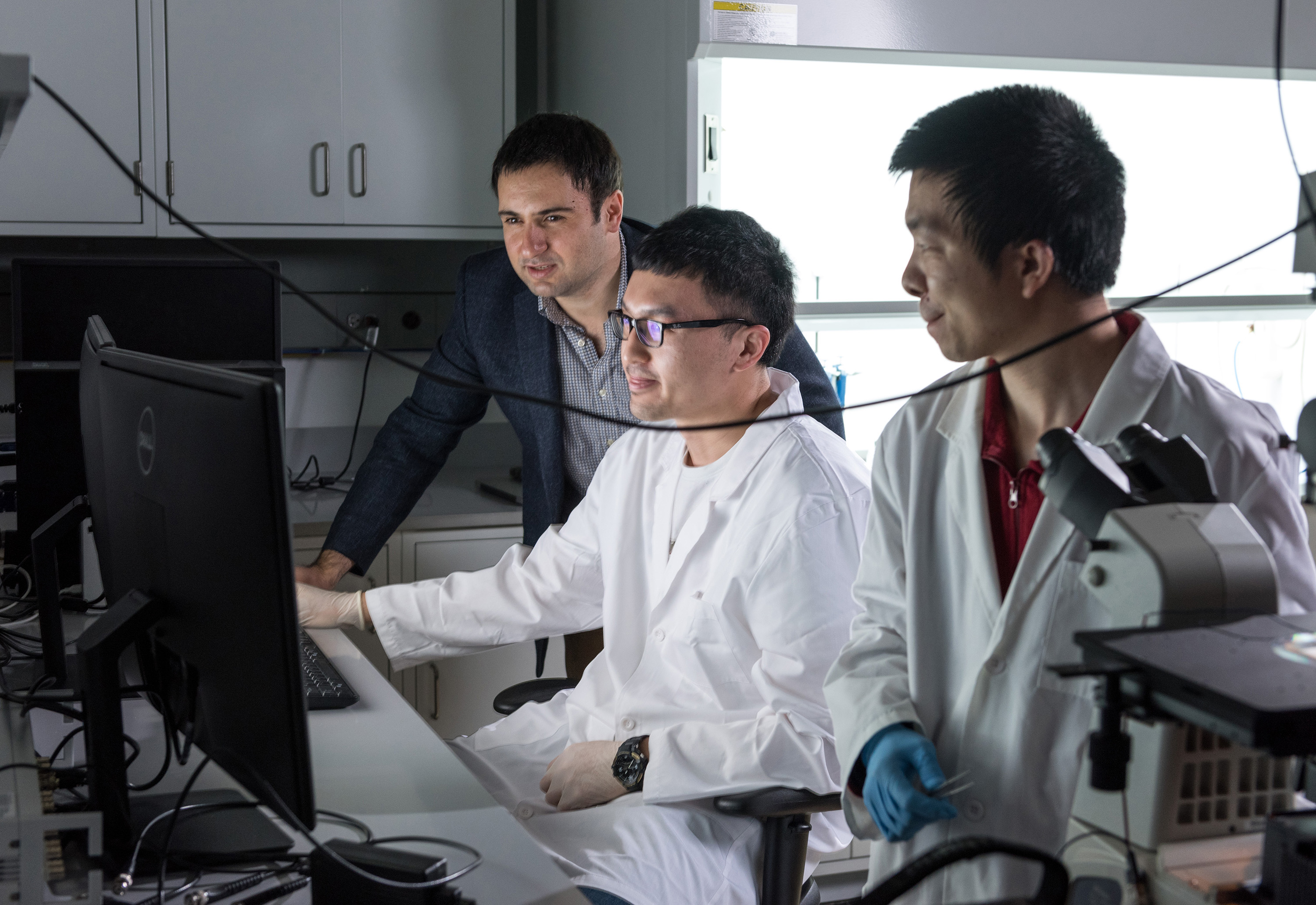 Georgia Tech researchers have developed a hybrid microfluidic chip that could provide the electronic intelligence that might one day allow inexpensive labs on a chip to conduct sophisticated medical testing outside the confines of hospitals and clinics. Shown are (l-r) Fatih Sarioglu, Ningquan Wang and Ruxiu Liu. (Credit: Rob Felt, Georgia Tech)