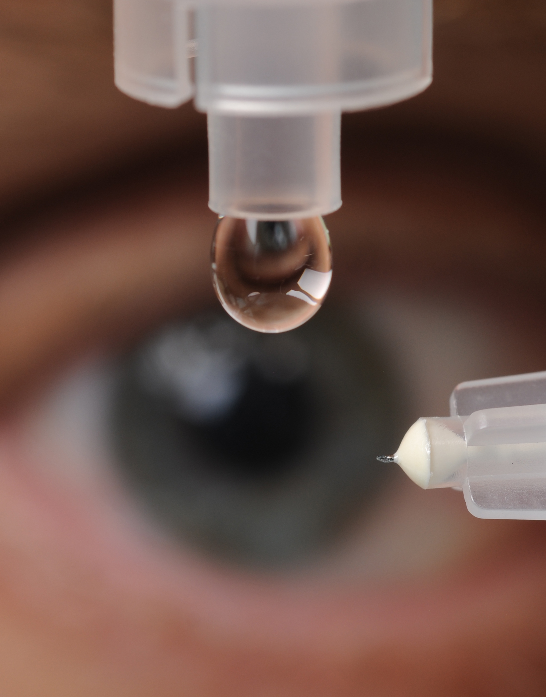 A microneedle used to inject glaucoma medications into the eye is shown next to a liquid drop from a conventional eye dropper. (Photo credit: Gary Meek).
