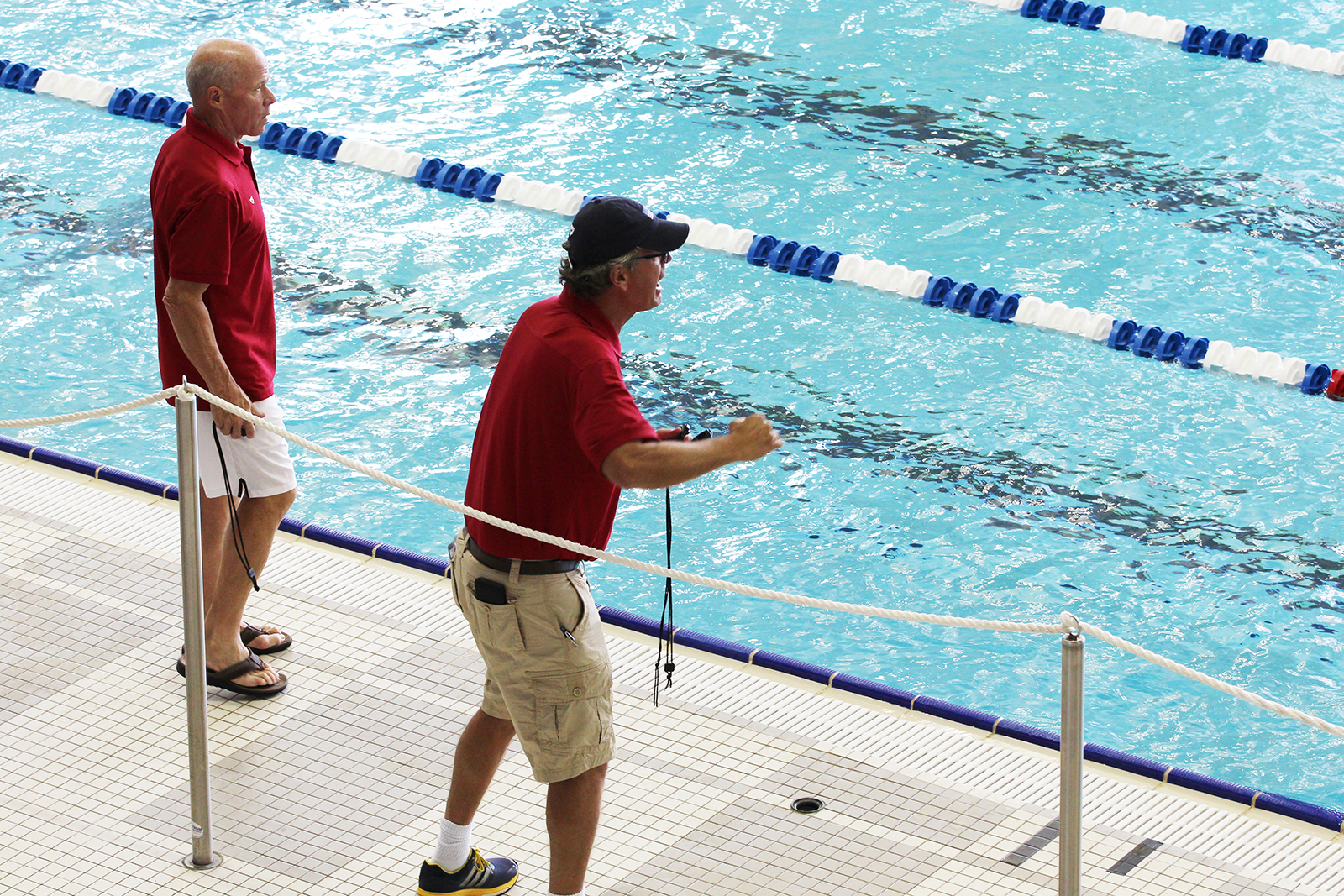 Jack Bauerle and Mike Bottom, assistant coaches for the U.S. Men's Olympic Swimming Team, cheer on the team at an open practice at Georgia Tech's McAuley Aquatic Center on July 30, 2016
