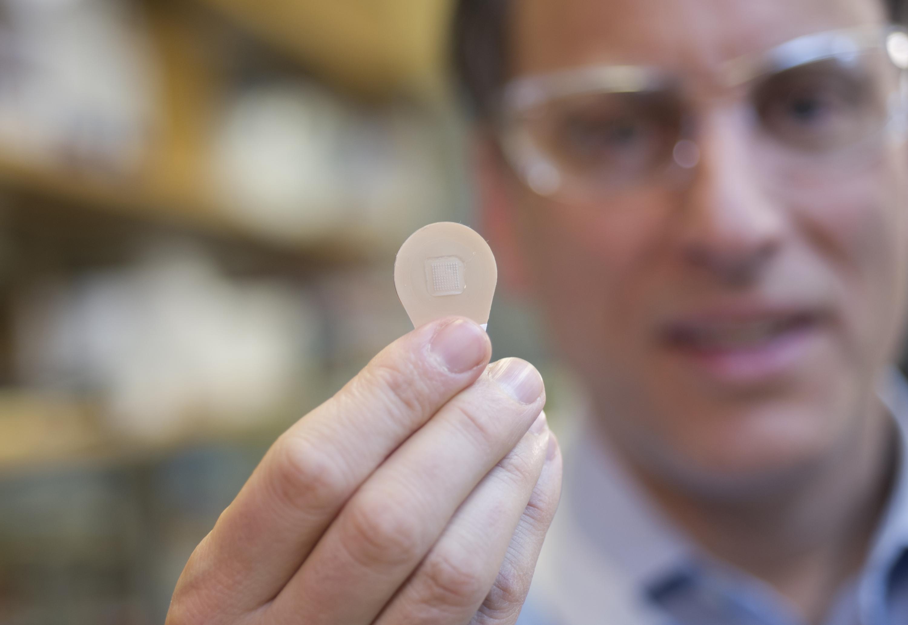 Mark Prausnitz, Ph.D., Georgia Tech Regents professor in the School of Chemical and Biomolecular Engineering, holds a microneedle vaccine patch containing needles that dissolve into the skin. (Credit: Christopher Moore, Georgia Tech)
