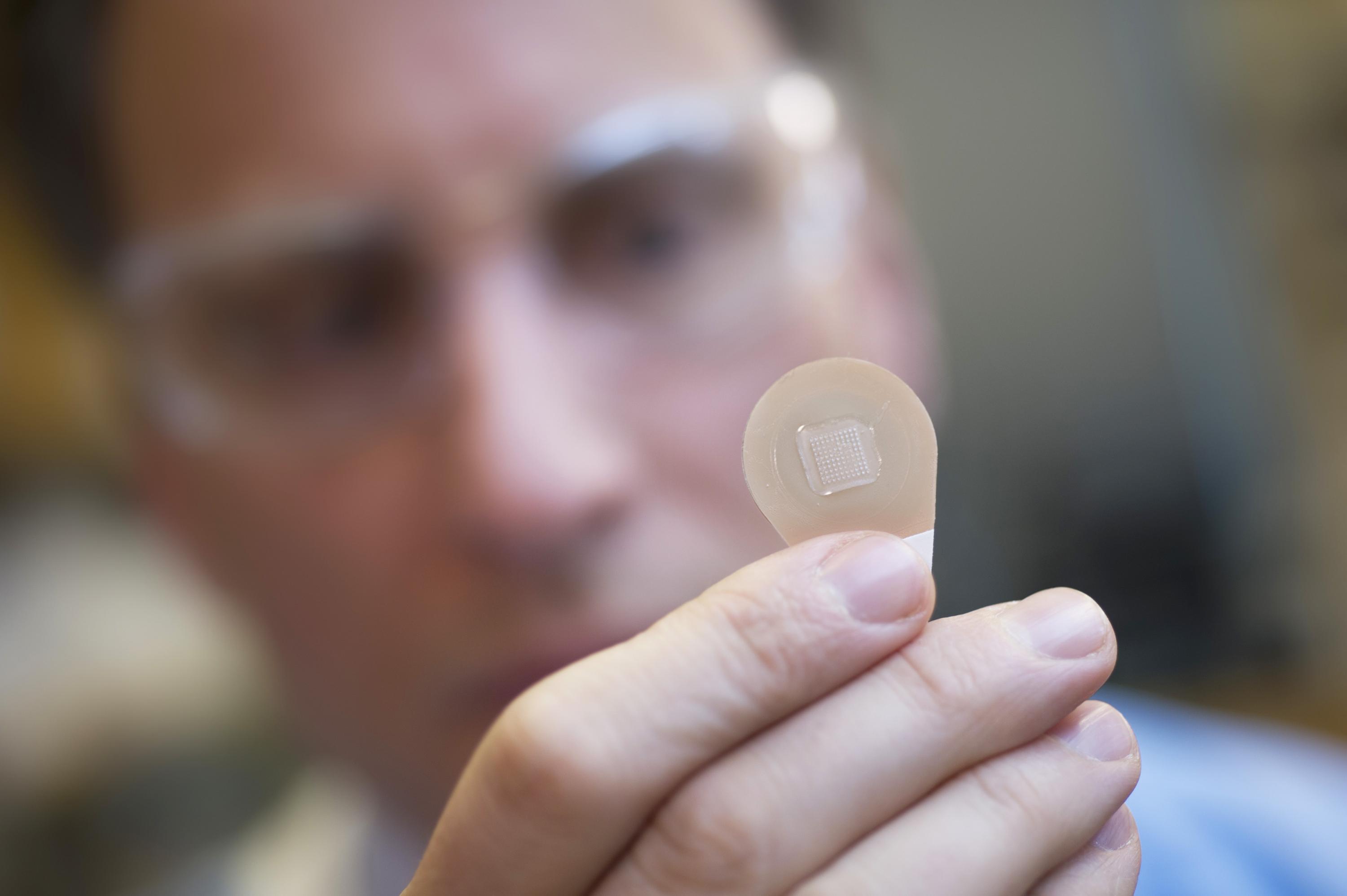 Mark Prausnitz, Ph.D., Georgia Tech Regents professor in the School of Chemical and Biomolecular Engineering, holds a microneedle vaccine patch containing needles that dissolve into the skin. (Credit: Christopher Moore, Georgia Tech)