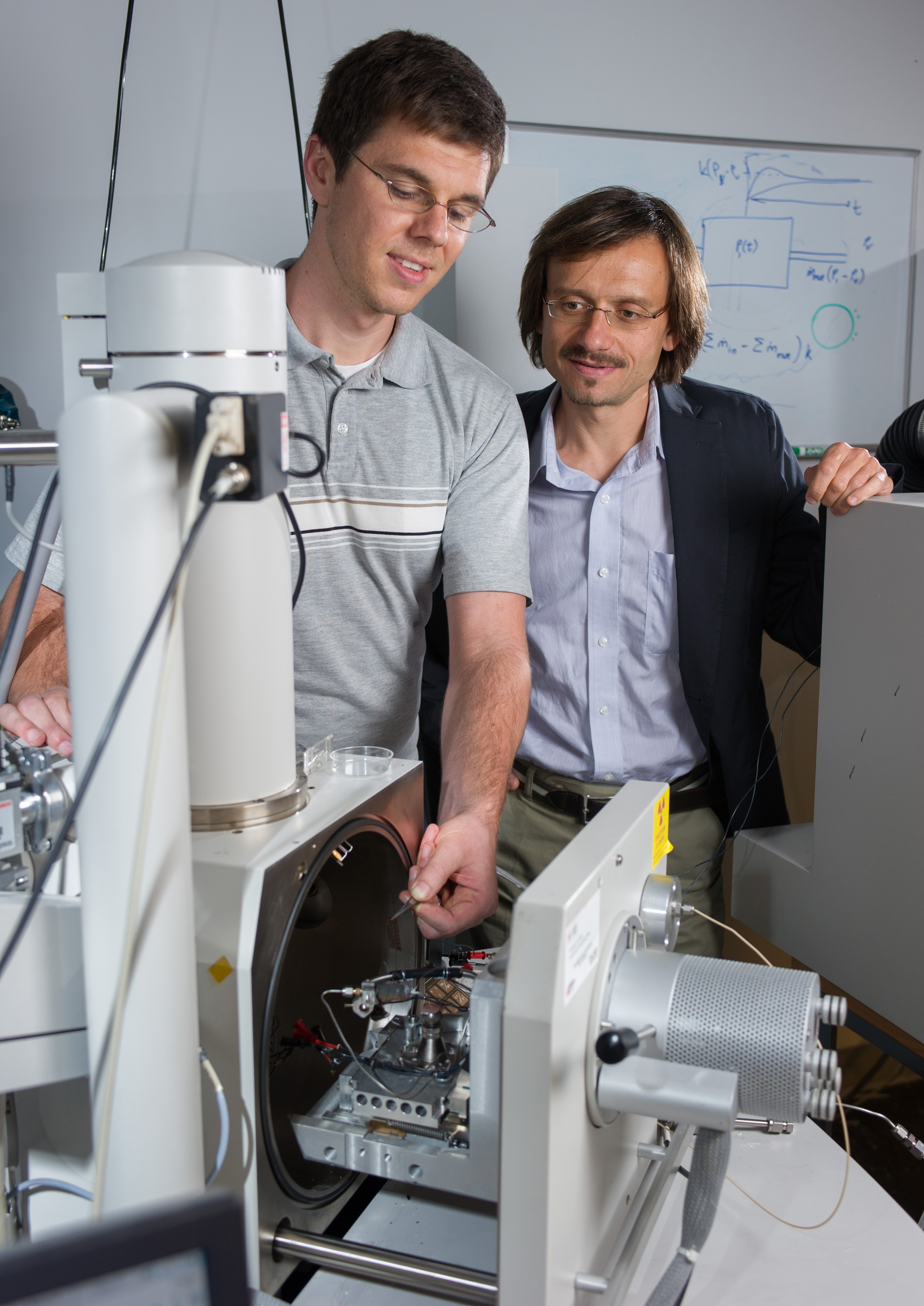 Georgia Tech Ph.D. candidate Matthew Henry and Professor Andrei Fedorov set up the precursor jet micro-nozzle inside a FEBID vacuum deposition chamber.  (Georgia Tech Photo: Rob Felt)