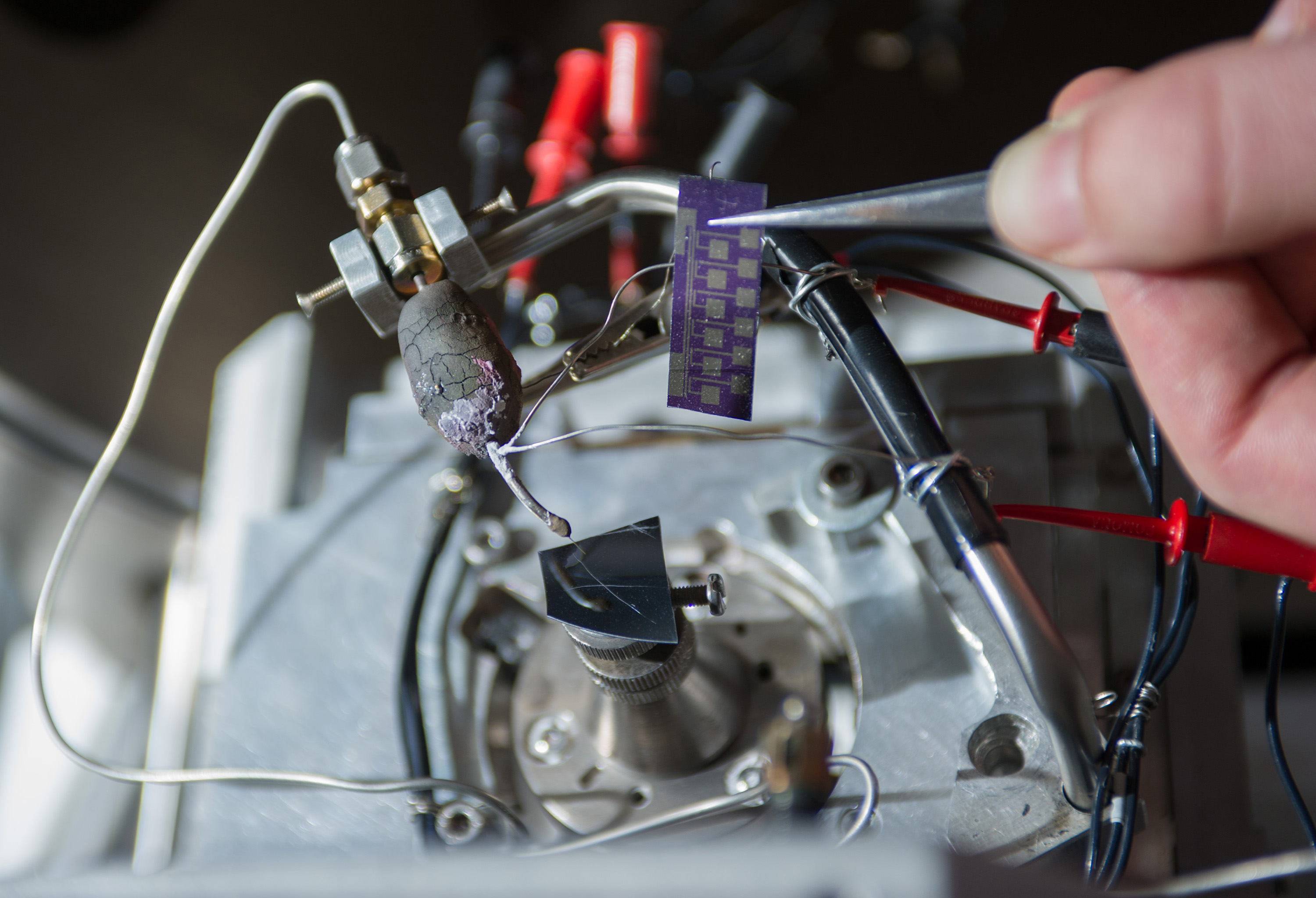 This image shows a heated capillary micro-nozzle installed on the deposition stage of an FEBID system, along with the test chip used for electrical characterization of deposits for graphene interconnects. (Georgia Tech Photo: Rob Felt)