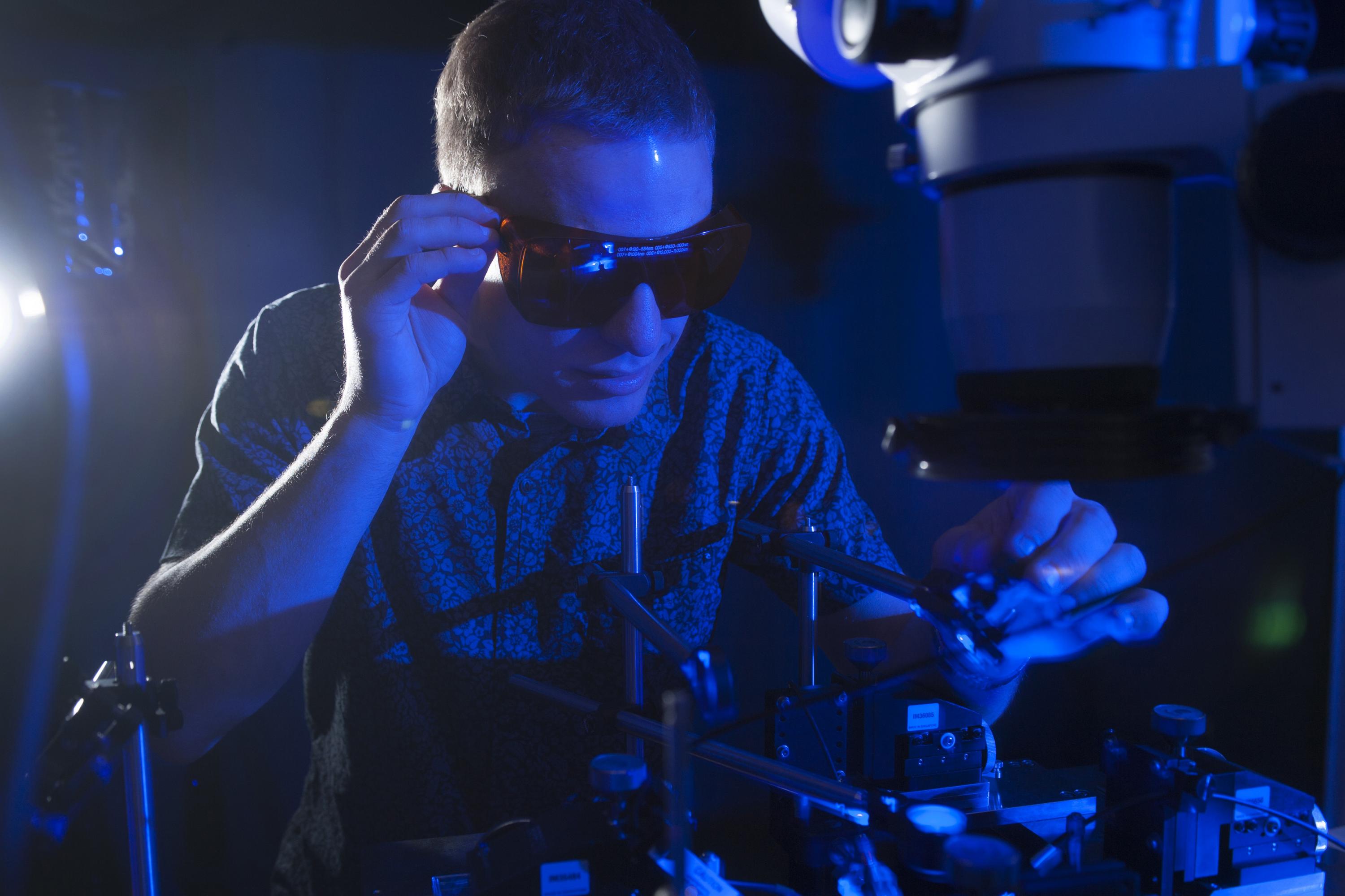 NSF Graduate Research Fellow Erik Anderson tests the conversion of blue light to electricity with a new higher efficiency rectenna design. (Credit: Christopher Moore, Georgia Tech)