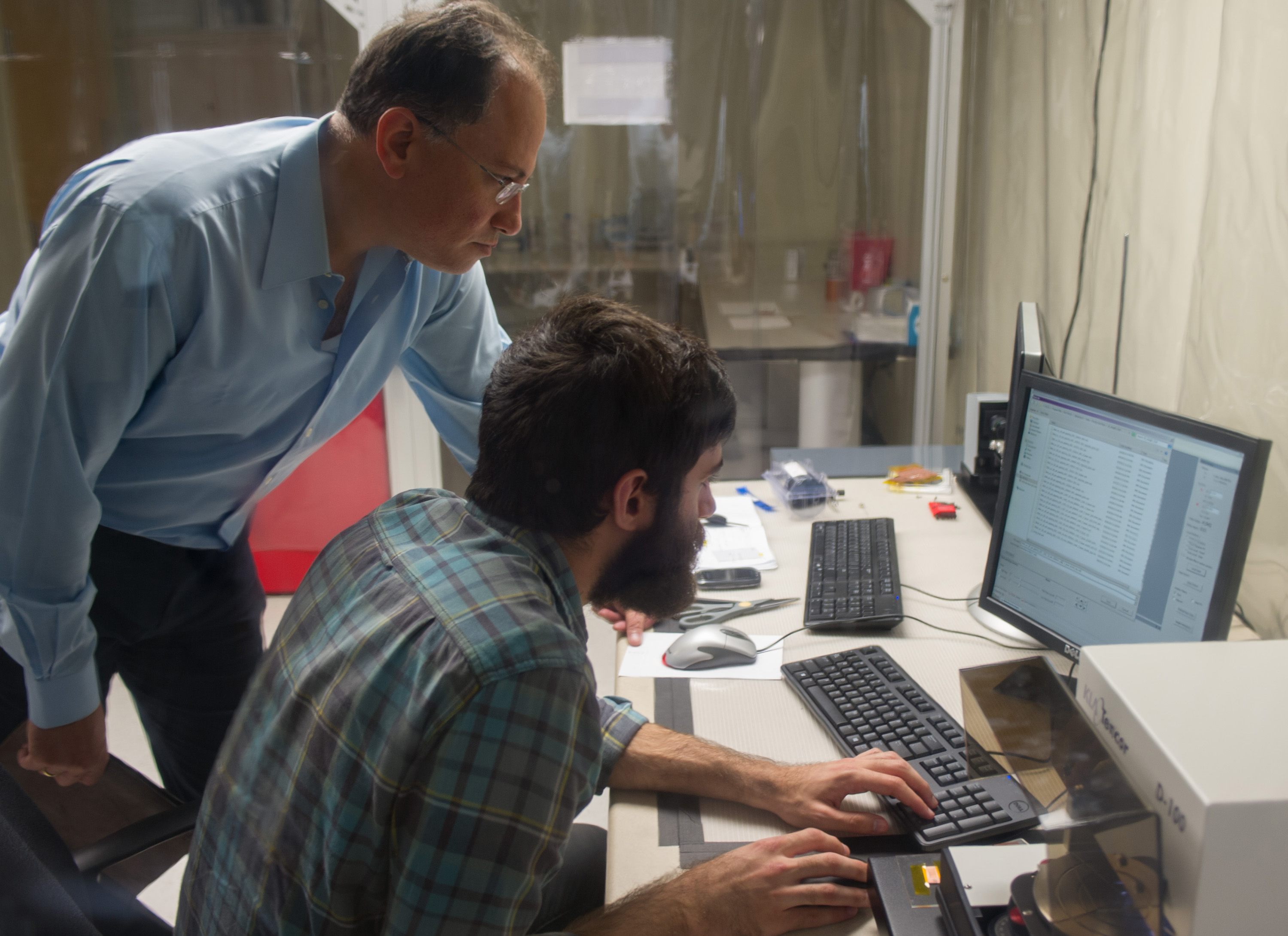 Georgia Tech professor Manos Tentzeris (left) and graduate student Bijan Tehrani analyze micron-scale inkjet printing RF fabrication. (Georgia Tech Photo: Rob Felt)