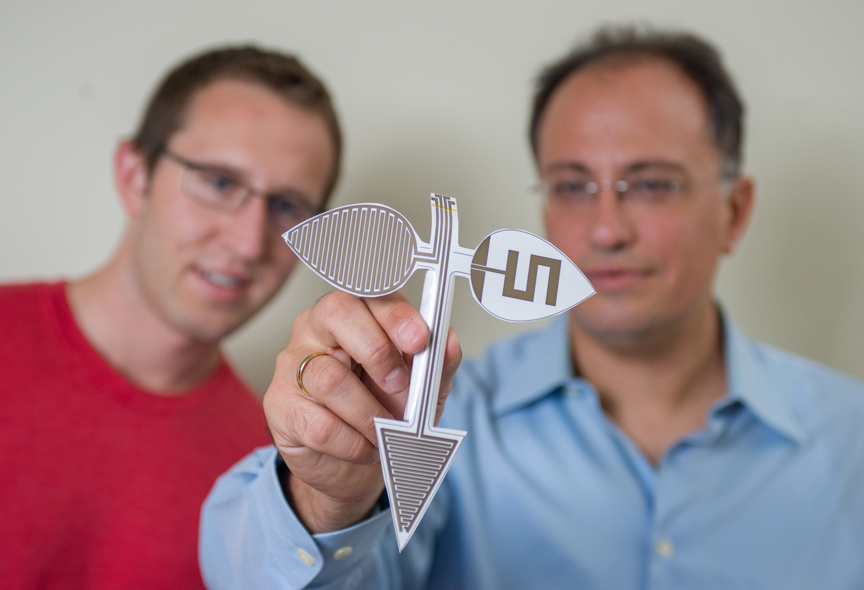 Georgia Tech professor Manos Tentzeris (right) and Ph.D. student Benjamin Cook examine the morphology of micron-sized inkjet-printed structures on flexible substrates. (Georgia Tech Photo: Rob Felt)