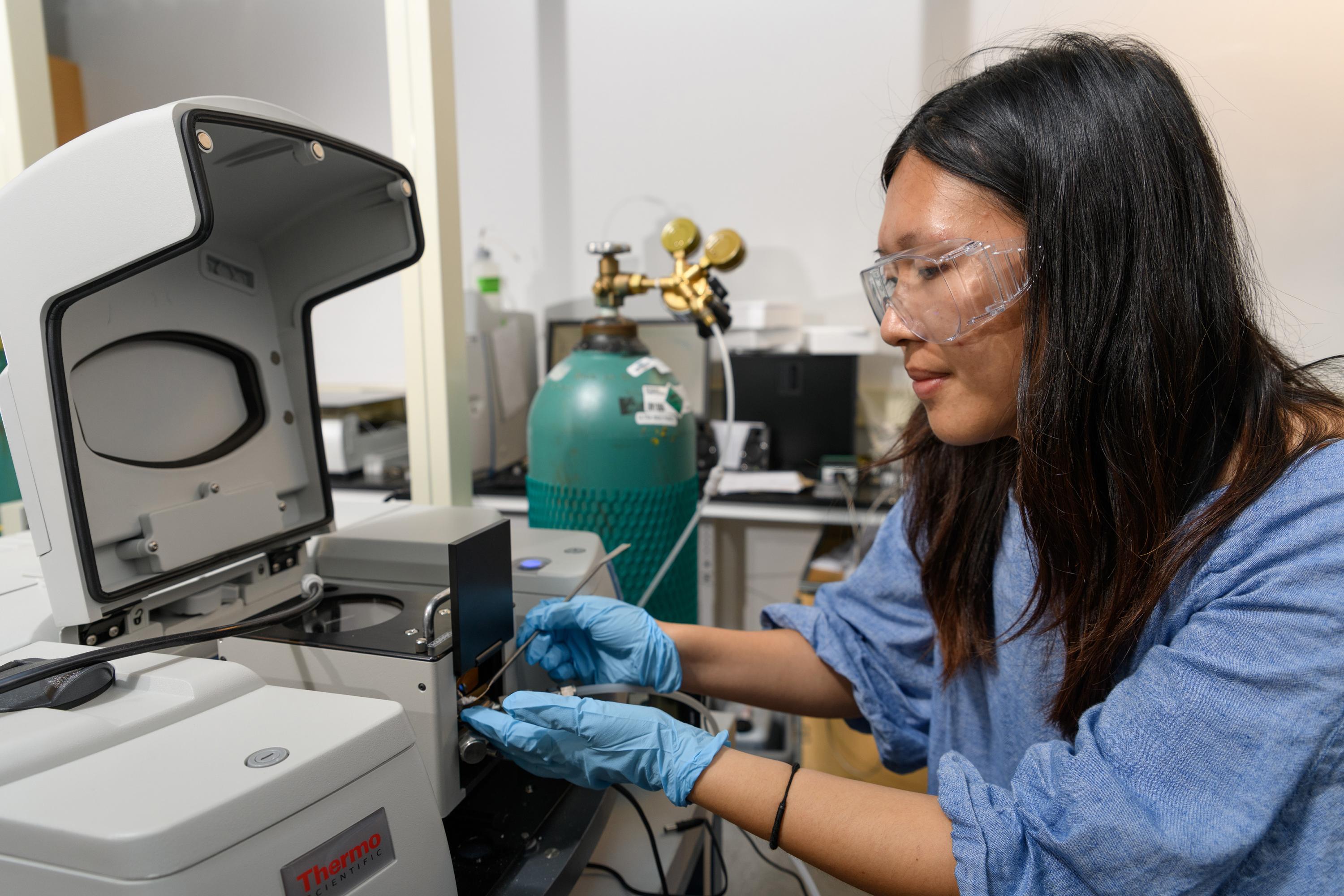 Georgia Tech graduate research assistant Yu-Hsuan Liu places a sample of titanium dioxide into test equipment in the laboratory of assistant professor Marta Hatzell. (Credit: Rob Felt, Georgia Tech)