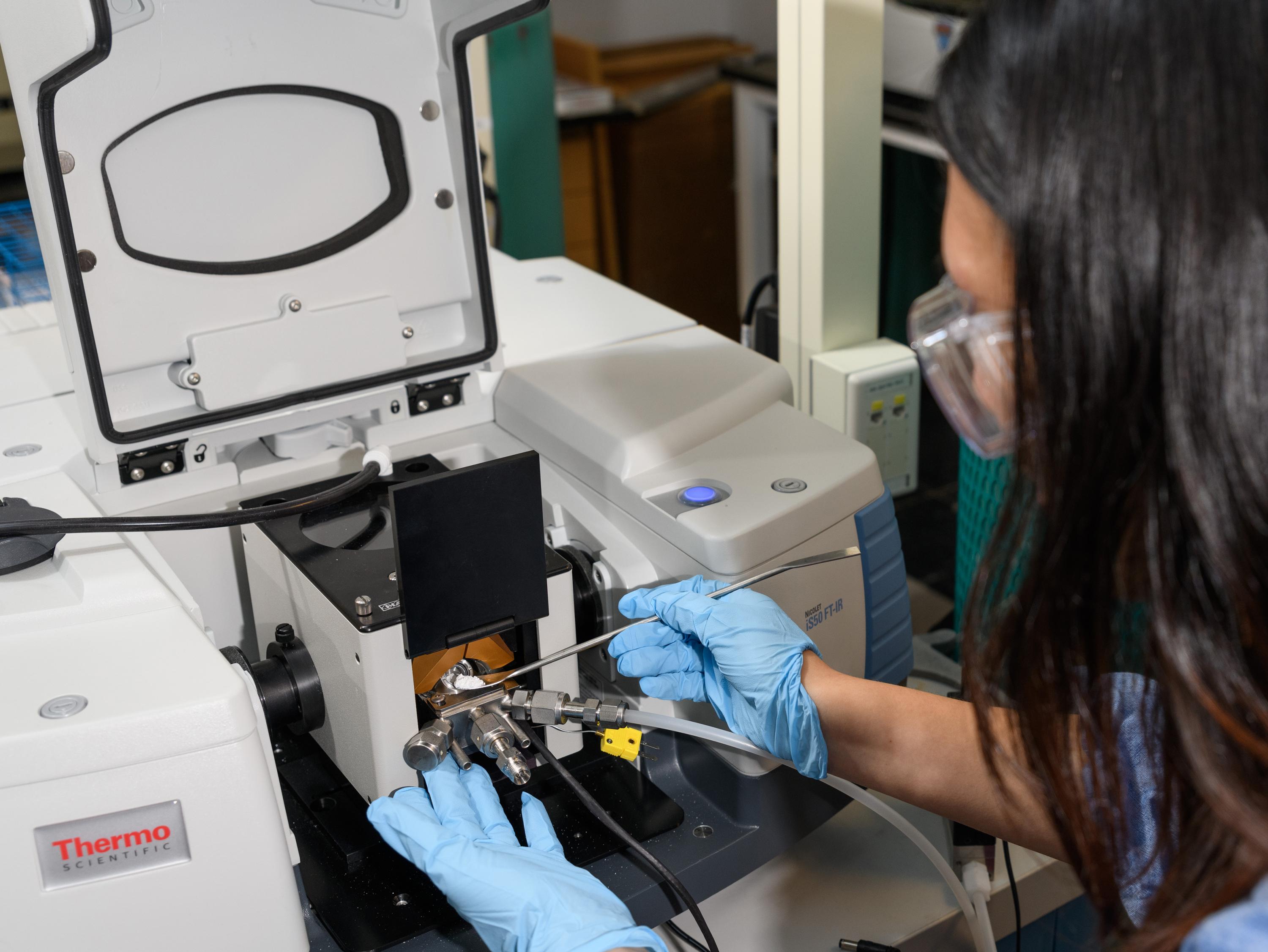 Georgia Tech graduate research assistant Yu-Hsuan Liu places a sample of titanium dioxide into test equipment in the laboratory of assistant professor Marta Hatzell. (Credit: Rob Felt, Georgia Tech)