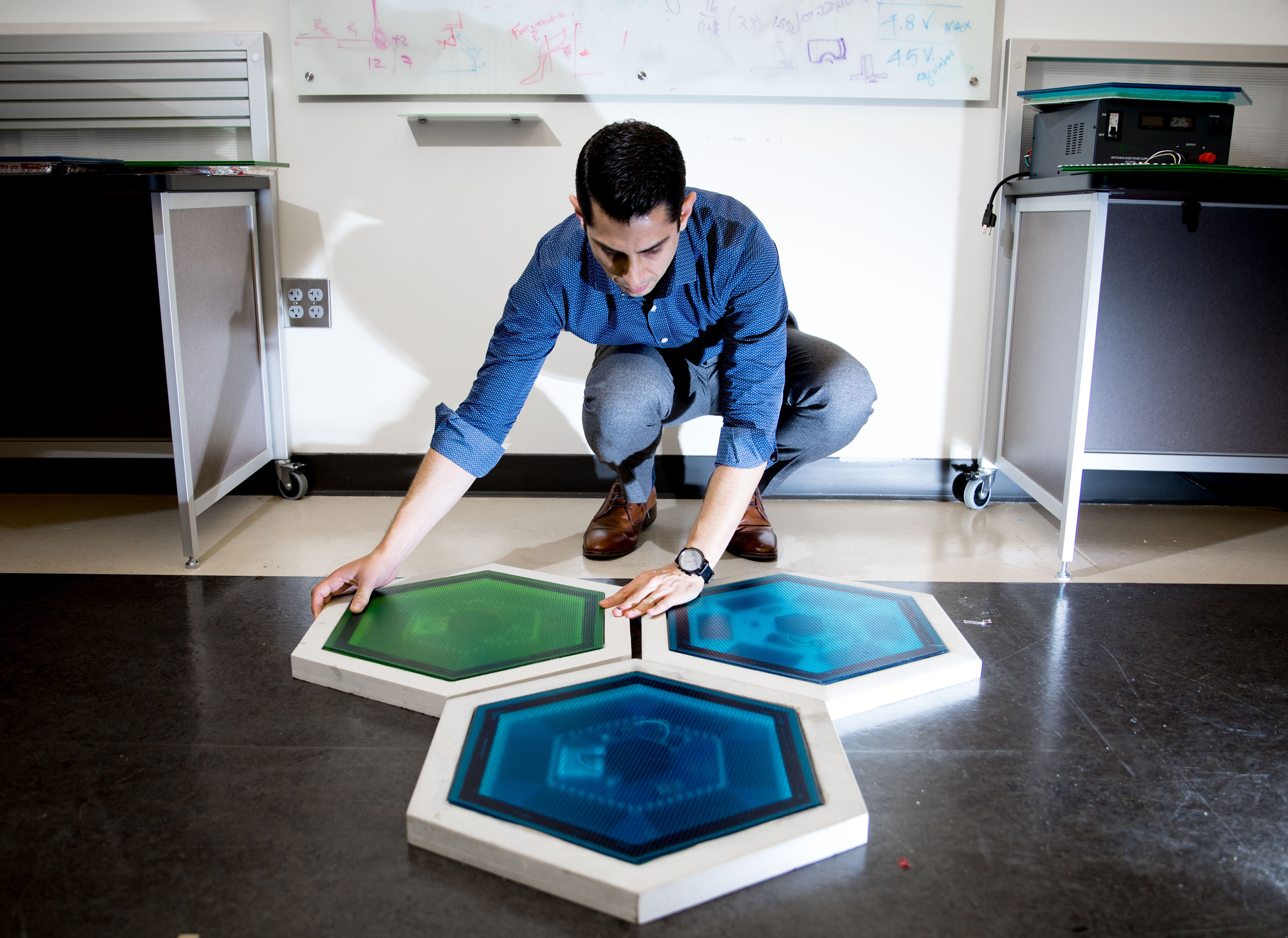 Ilan Stern, a GTRI senior research scientist, shows piezoelectric tiles that will be used to create a lighted outdoor footpath at the NASA Kennedy Space Center’s Visitor Complex at Cape Canaveral, Florida. He’s holding the electronic components used in the tiles. (Credit: Branden Camp, Georgia Tech)