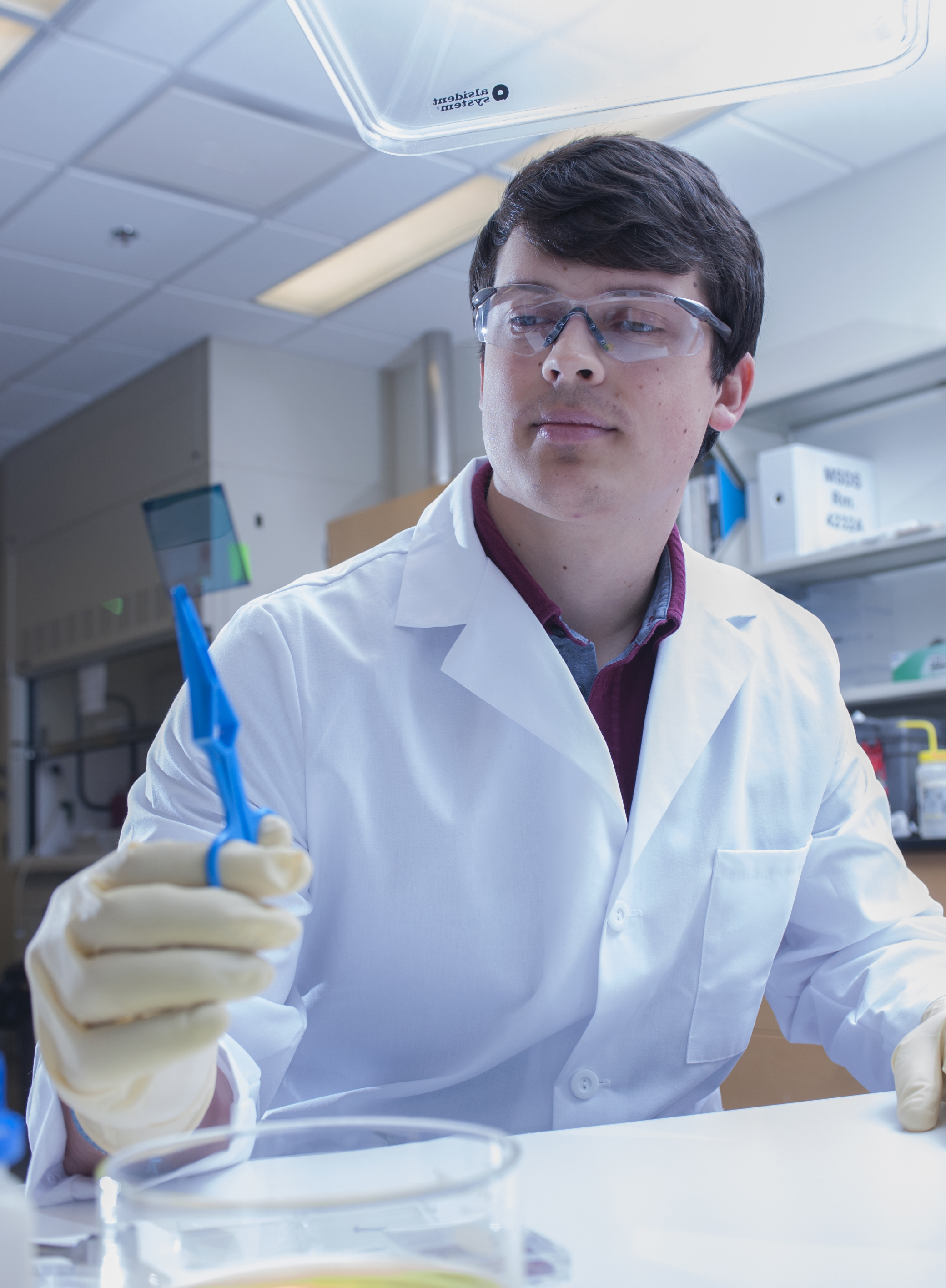 Graduate student Vladimir Kolesov, lead author of the paper, holding an electrically-doped polymer film. (Credit: Christopher Moore, Georgia Tech)