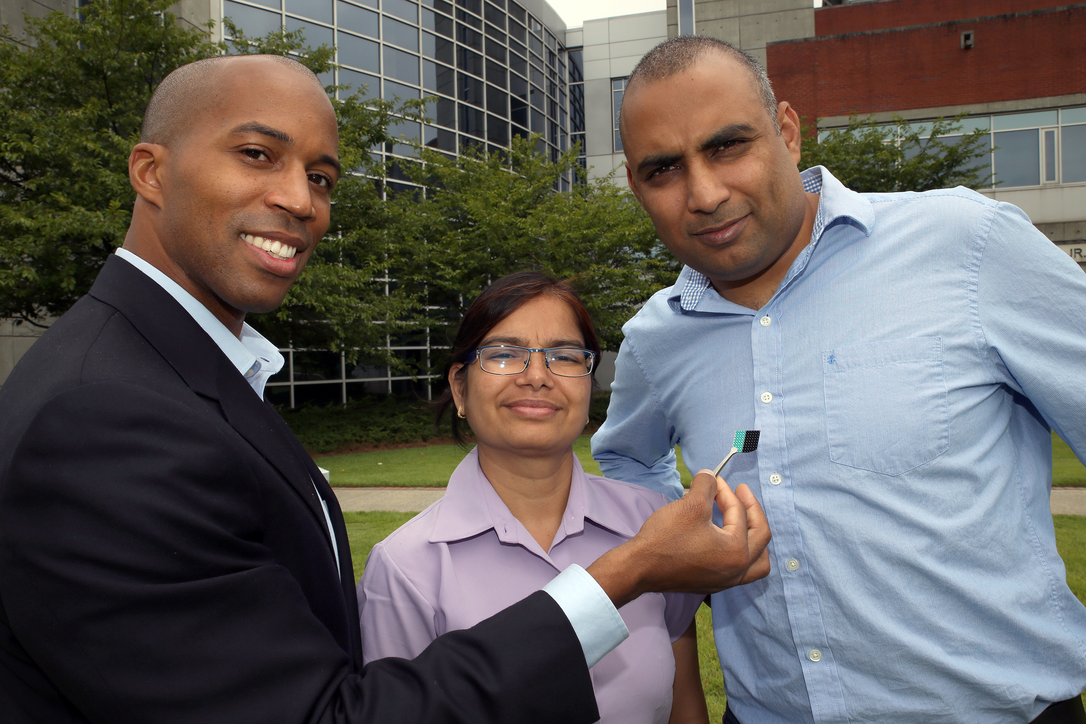 Professor Baratunde Cola (left) holds a carbon nanotube optical rectenna device. With him are Asha Sharma (center) and Virendra Singh from his group, who are collaborators on the development. (Credit: Candler Hobbs, Georgia Tech)