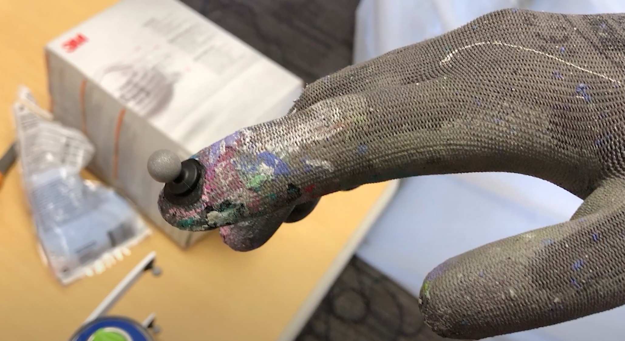 An artist's hand movements are captured with fingertip sensors. 