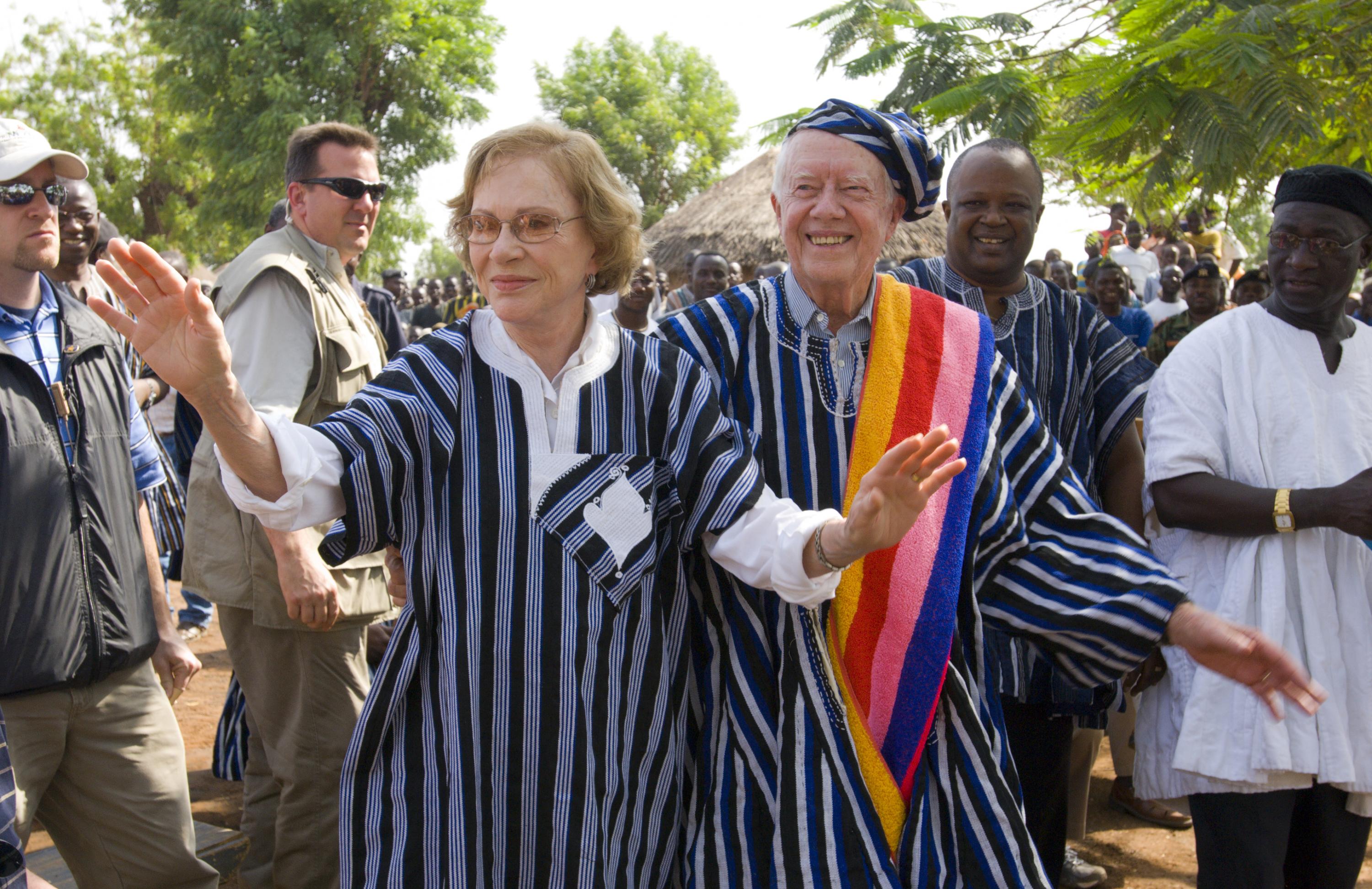 Former U.S. President Jimmy Carter and former First Lady Rosalynn Carter wear traditional Ghanaian attire, a gift from the chief of Tingoli village in northern Ghana, where The Carter Center, in partnership with Ghana's Ministry of Health, worked to eradicate Guinea worm disease and eliminate trachoma. The Carters visited the village Feb. 8, 2007, as part of a two-week health tour of remote African villages. Photo credit: The Carter Center. 