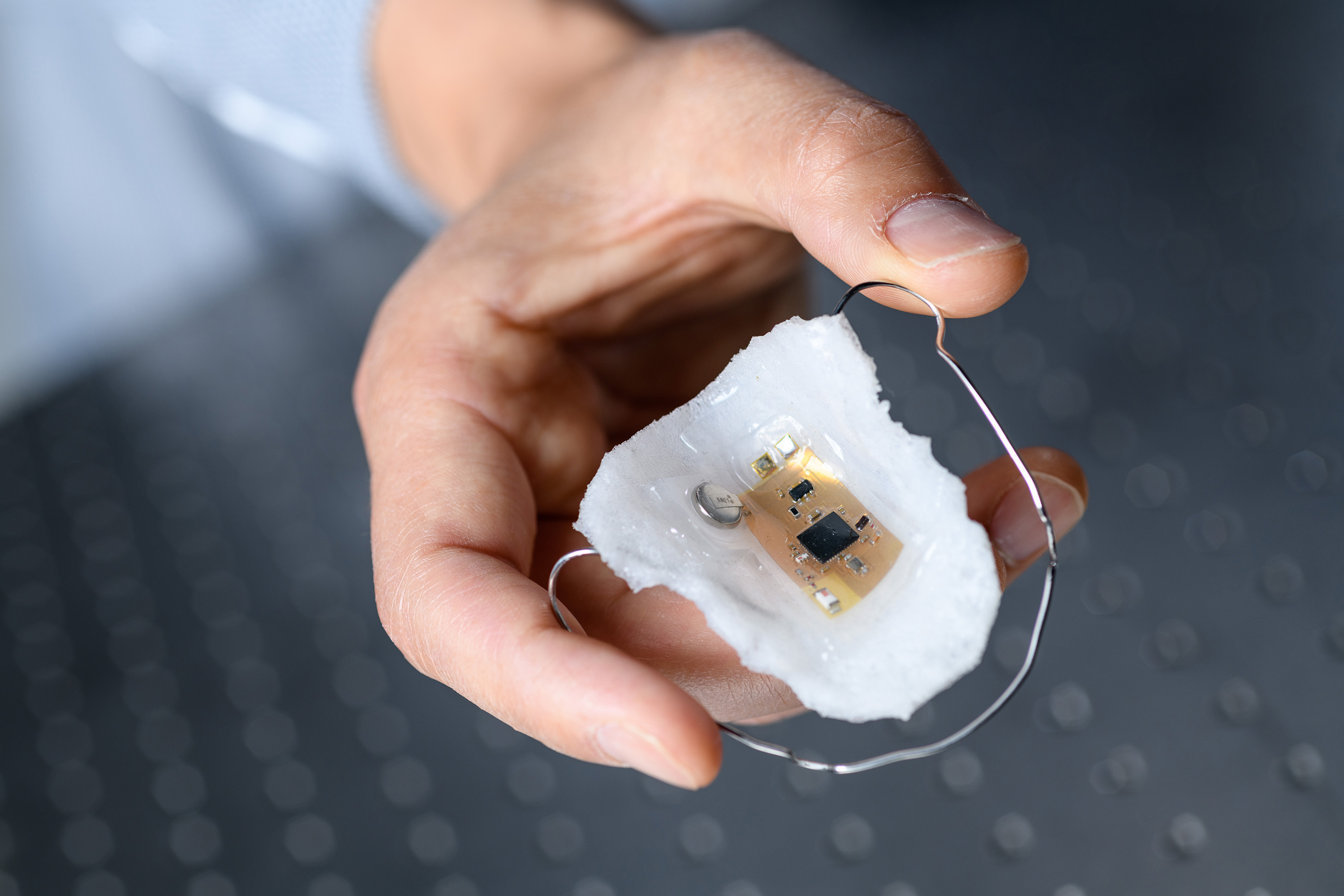 The intraoral electronics with a sodium sensor is based on a breathable elastomeric membrane that resembles a dental retainer. The ultrathin device is flexible and stretchable, and can wirelessly transmit data up to 10 meters. (Credit: Rob Felt, Georgia Tech).