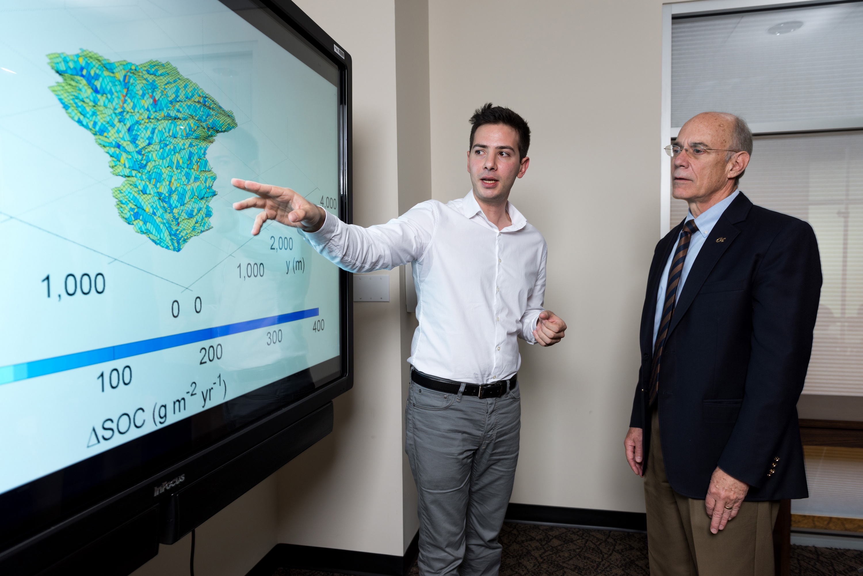 Yannis Dialynas, a hydrology Ph.D. student in Georgia Tech’s School of Civil and Environmental Engineering, and Georgia Tech Provost Rafael L. Bras, discuss a model of soil erosion. This research is studying the role of erosion on carbon cycling. (Credit: Rob Felt, Georgia Tech)