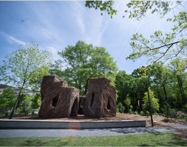 Image of Stickworks sculpture by Patrick Dougherty entitled "A Chip off the Ol' Block". As was the original intent of this natural, woven fortress constructed in 2020, it has succumbed to the elements and will be responsibly and sustainably removed from its location in the EcoCommons in the fall of 2023.
