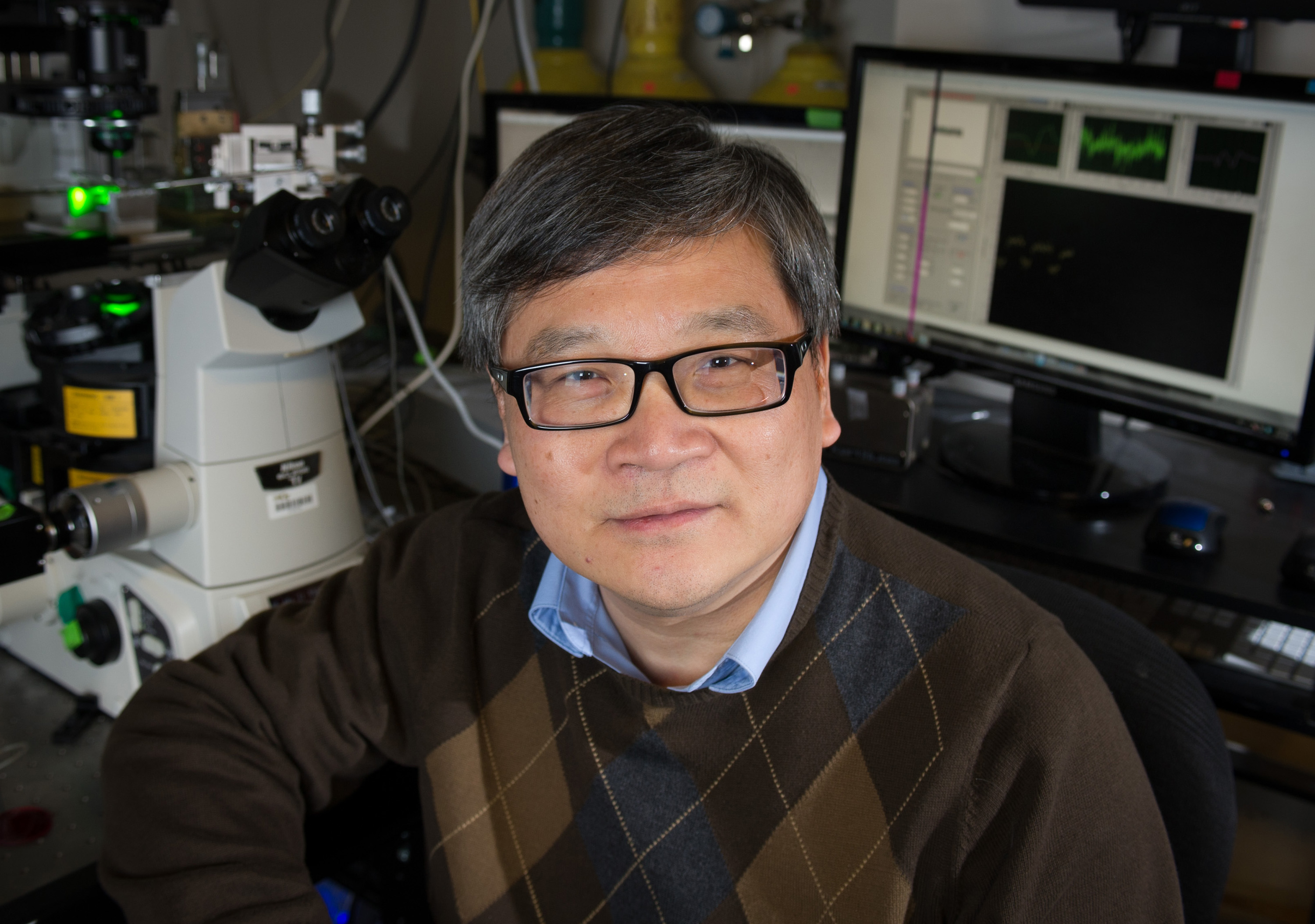 Cheng Zhu, a Regents’ professor in the Wallace H. Coulter Department of Biomedical Engineering at Georgia Tech and Emory University, is shown with biomembrane force probe equipment. (Georgia Tech Photo: Rob Felt)