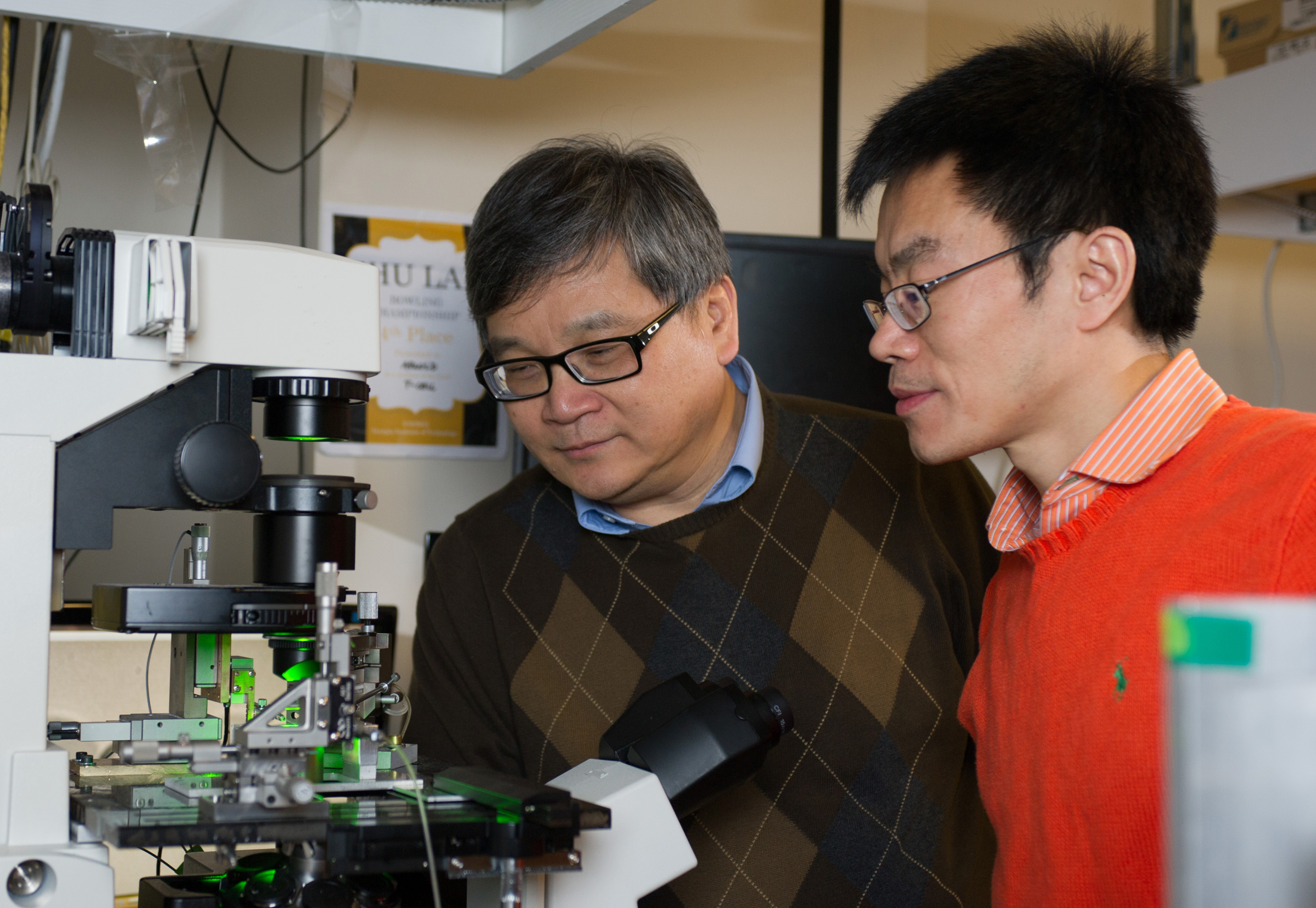 Researchers (l-r) Cheng Zhu and Baoyu Liu observe a biomembrane force probe experiment. (Georgia Tech Photo: Rob Felt)