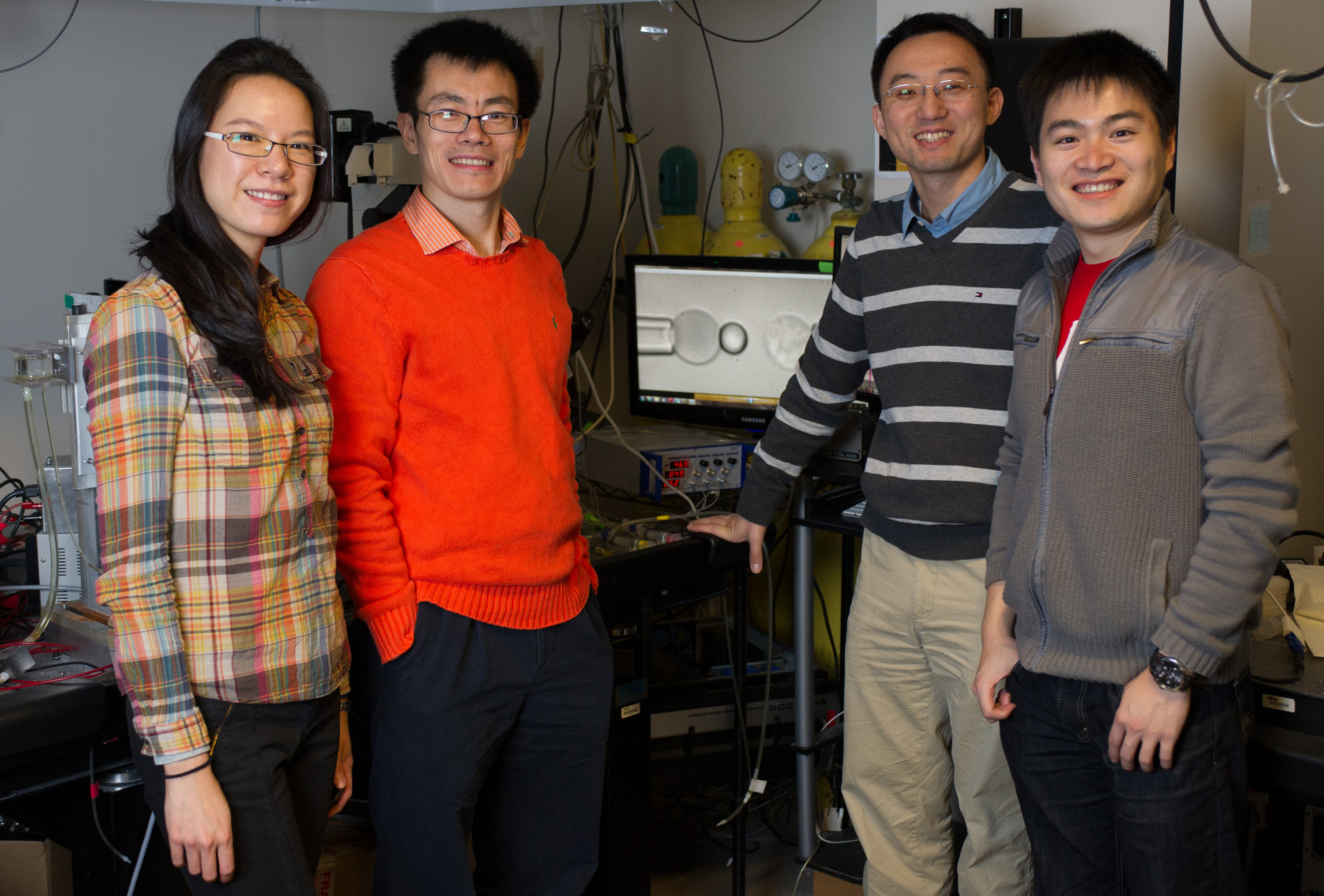 Members of the Zhu research laboratory include (l-r) Ke Bai, Baoyu Liu, Wei Chen and Chenghao Ge. Here, are they are shown with biomembrane force probe equipment. (Georgia Tech Photo: Rob Felt)