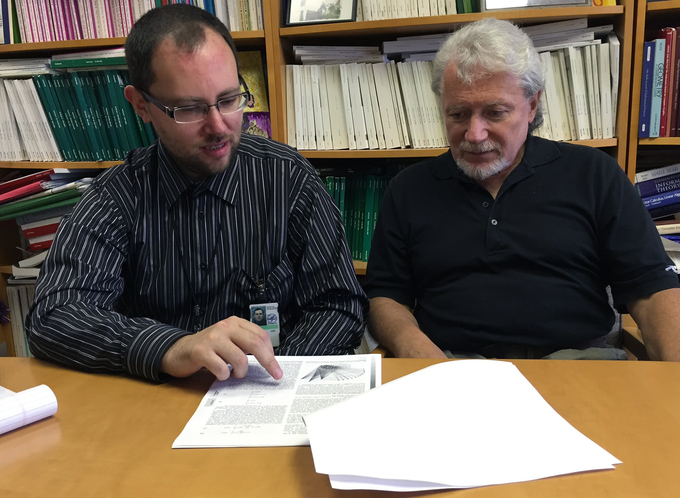 Pavel Skums (left), a regular fellow with the Centers for Disease Control and Prevention (CDC), and Leonid Bunimovich, a Regent’s Professor at the Georgia Institute of Technology, explain their new paper on Hepatitis C behavior. (Credit: John Toon)