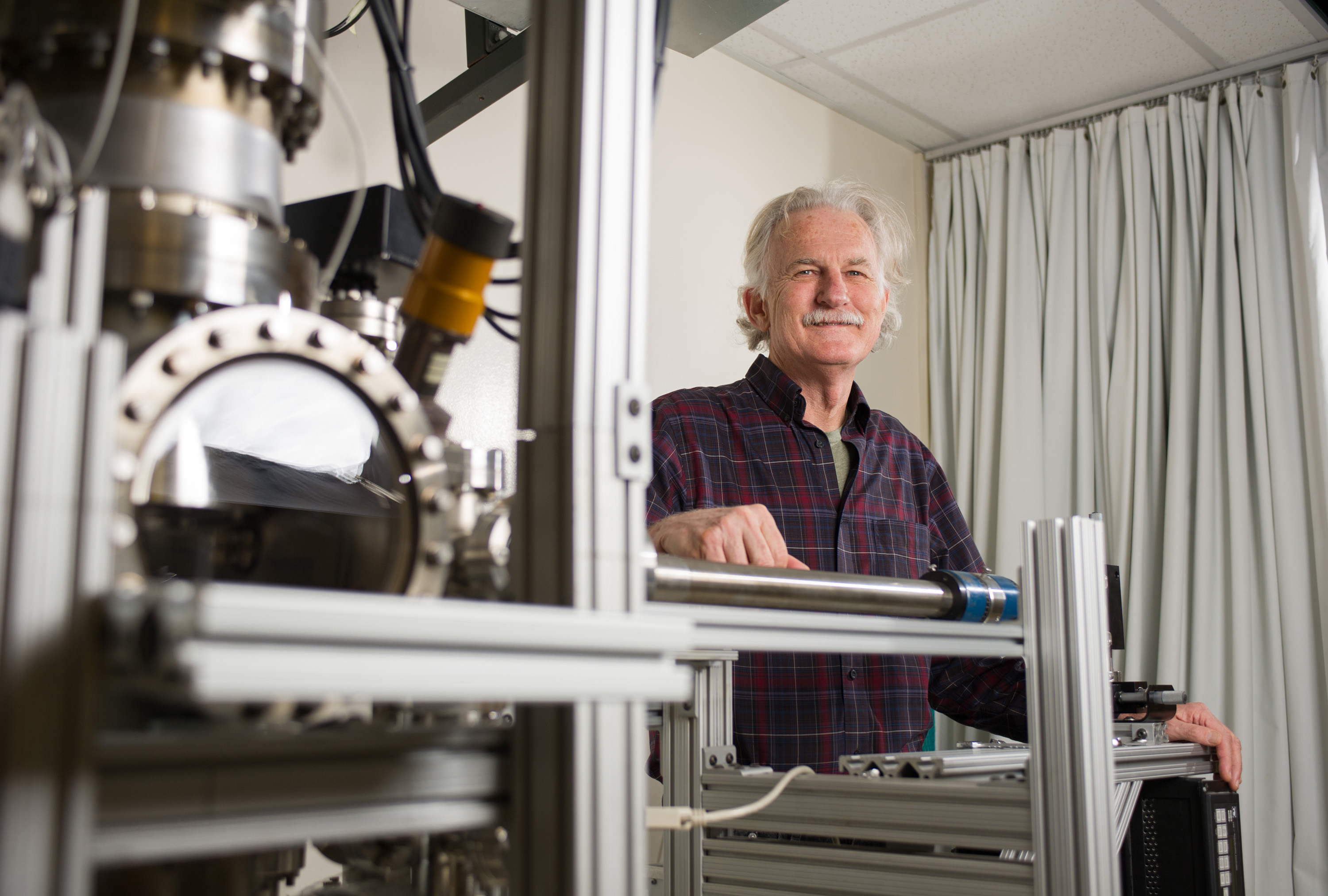 Walt de Heer, a Regent’s professor in the School of Physics at the Georgia Institute of Technology, poses with equipment used to measure the properties of graphene nanoribbons. De Heer and collaborators from three other institutions have reported ballistic transport properties in graphene nanoribbons that are about 40 nanometers wide. (Georgia Tech Photo: Rob Felt)
