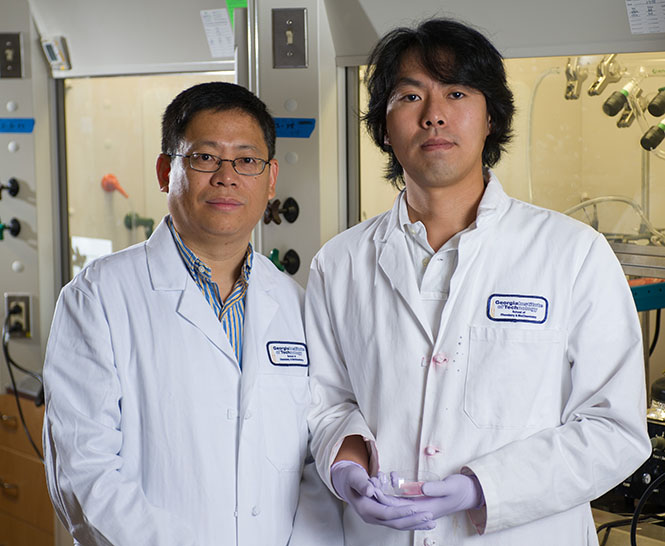 Younan Xia (left) and post-doctoral fellow Dong Choon Hyun, who is holding a sample containing the microscale polymer bottles. (Credit: Rob Felt)