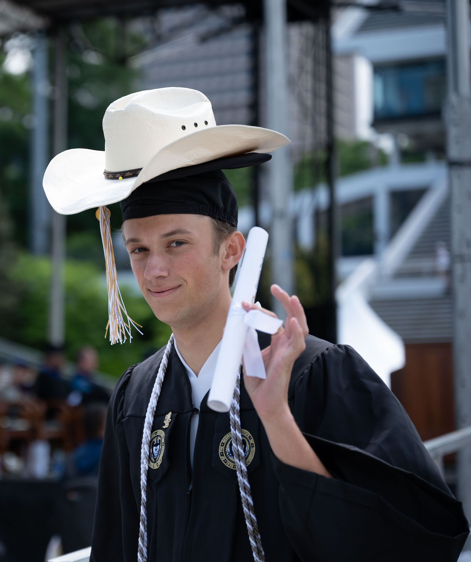 bachelor's ceremony, male wearing cowboy hat over mortar board