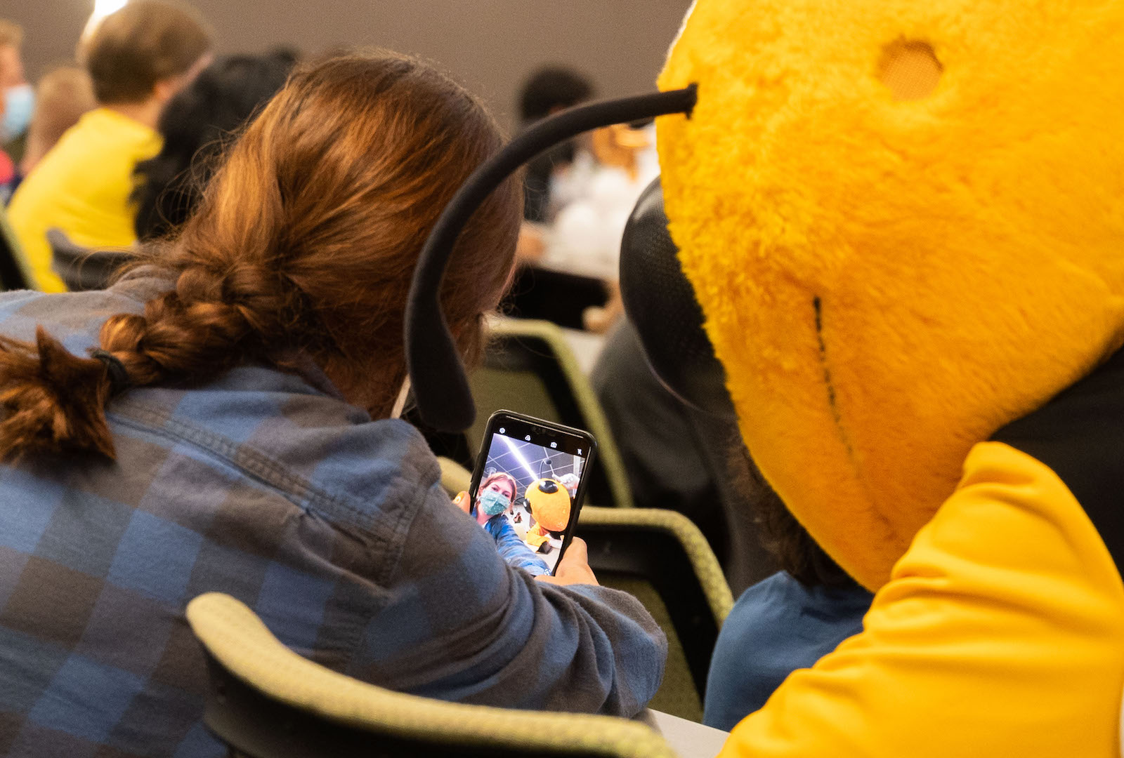 Student taking a selfie with Buzz at Graduate Student Convocation