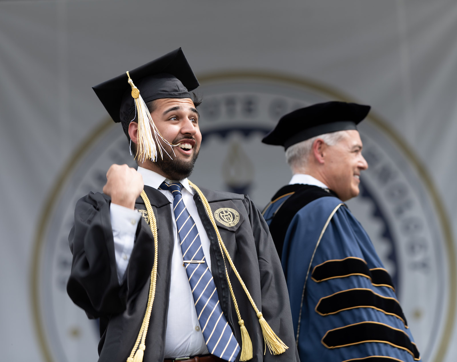 excited student on stage at bachelor's ceremony