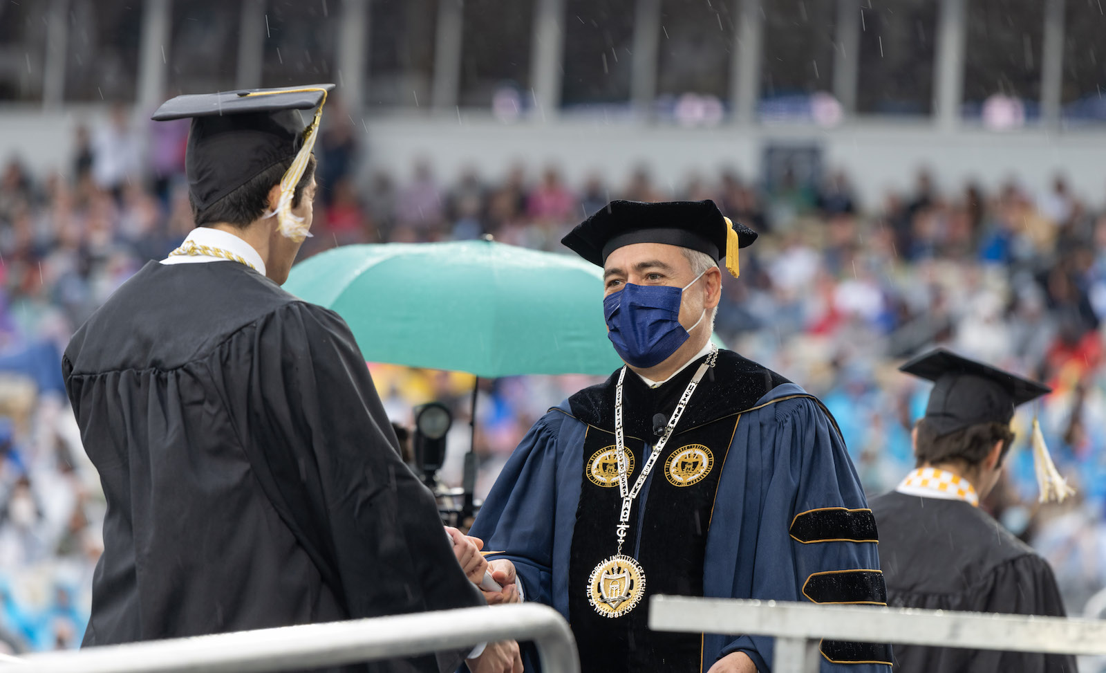 President Cabrera handing out diplomas in the rain. 
