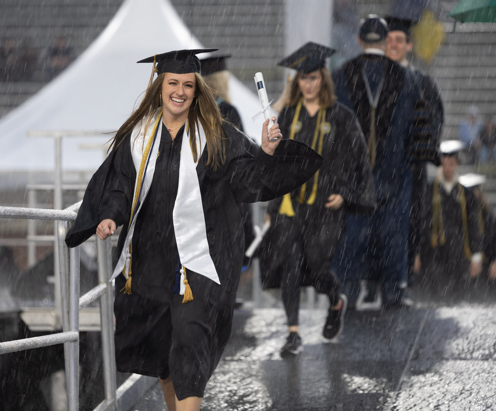 Woman holding diploma in the rain