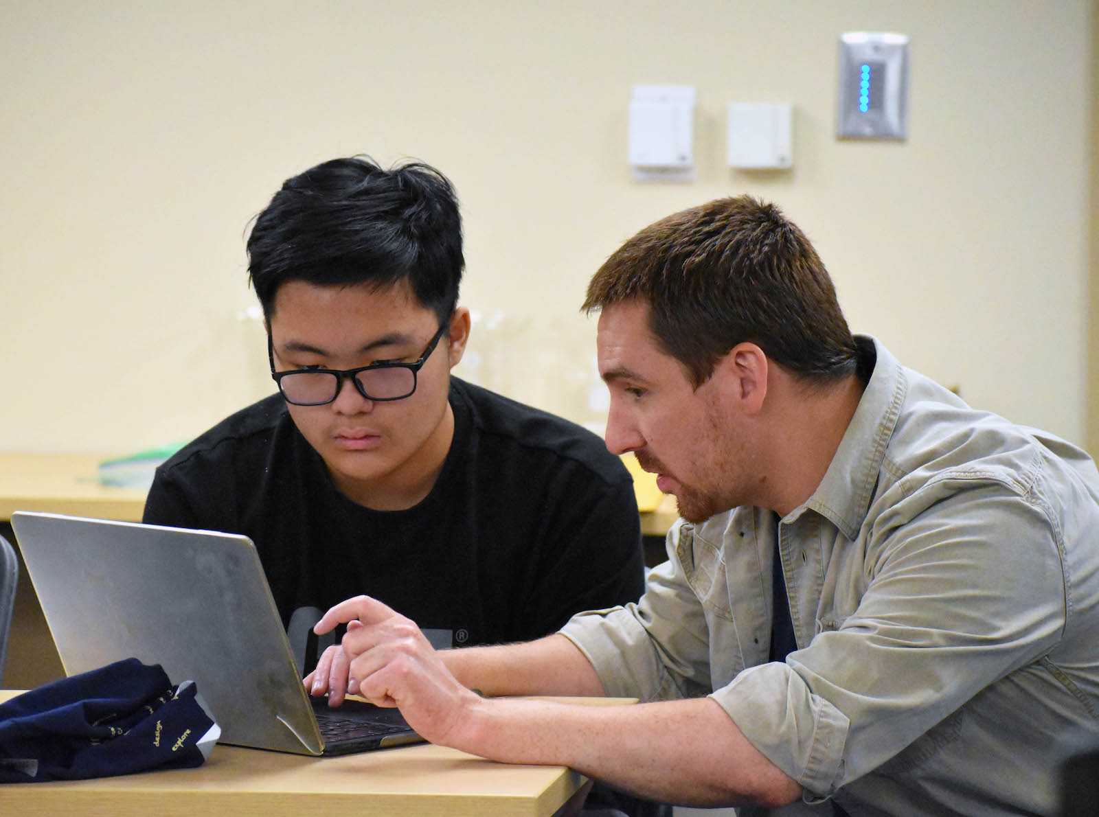 Instructor Josh King shows a high school student how a coding language can be used to make content recommendations. 