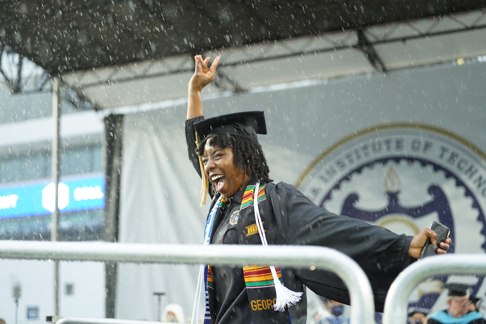 Graduate on stage in the rain. 